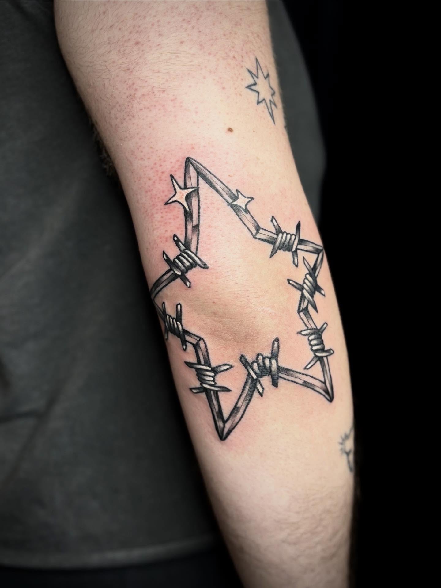 Barbed wire star black and grey tattoo on the forearm by Mim