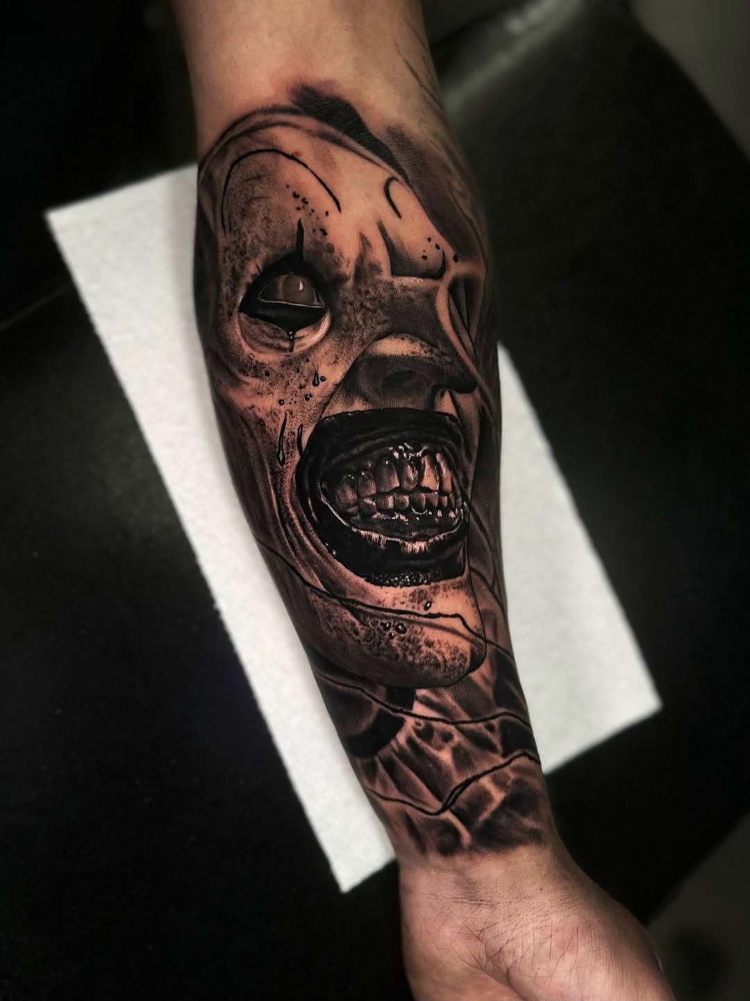 Screaming clown face realism tattoo on the forearm by Jesse White, Mentor, Ohio