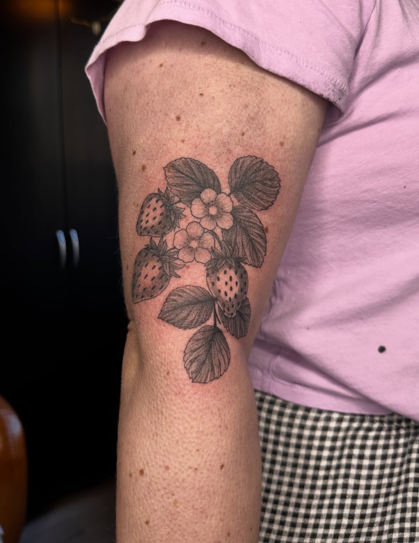 Strawberry plant black and grey tattoo on the forearm by Emma Thompson