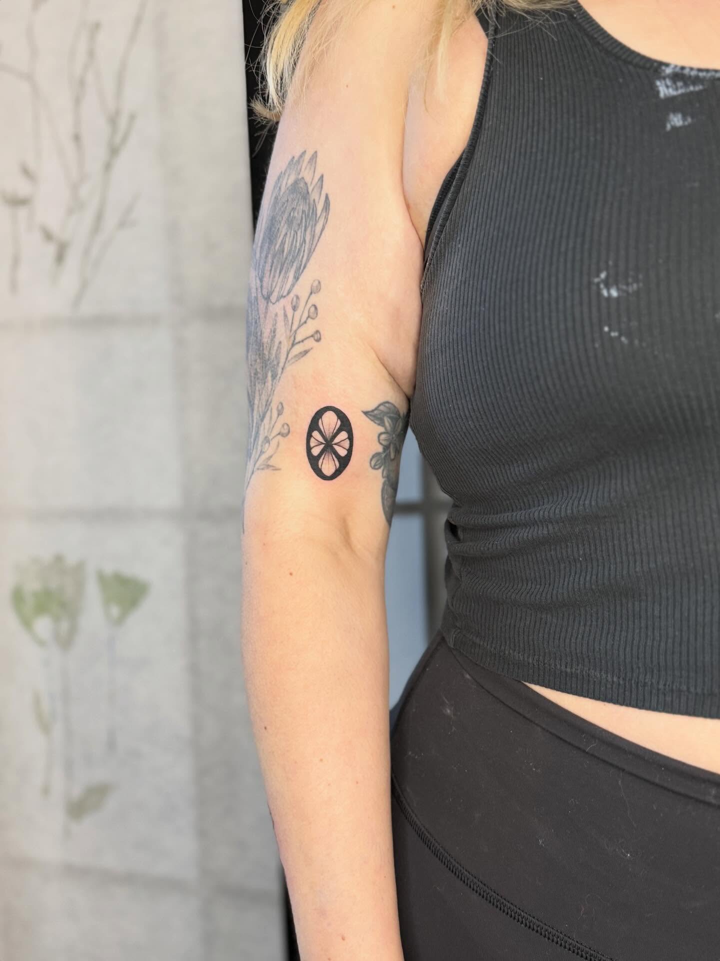 Slice of lemon black and grey tattoo on the forearm by Noelle Adrienne Tattoos
