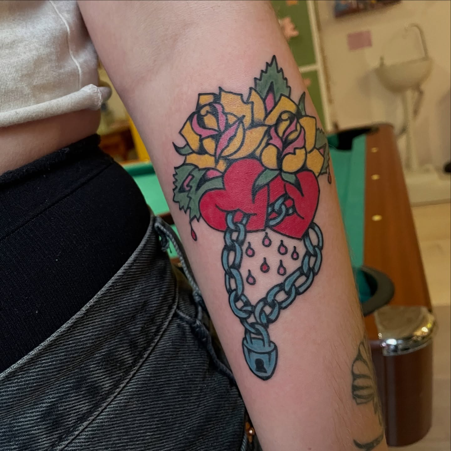 Heart with chains and flowers American traditional tattoo on the forearm by zoe ๐