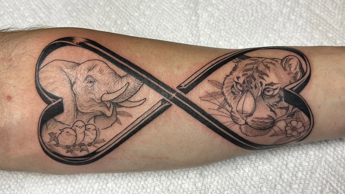 Infinity symbol with elephant and tiger realism tattoo on the forearm by Izabelle Inks