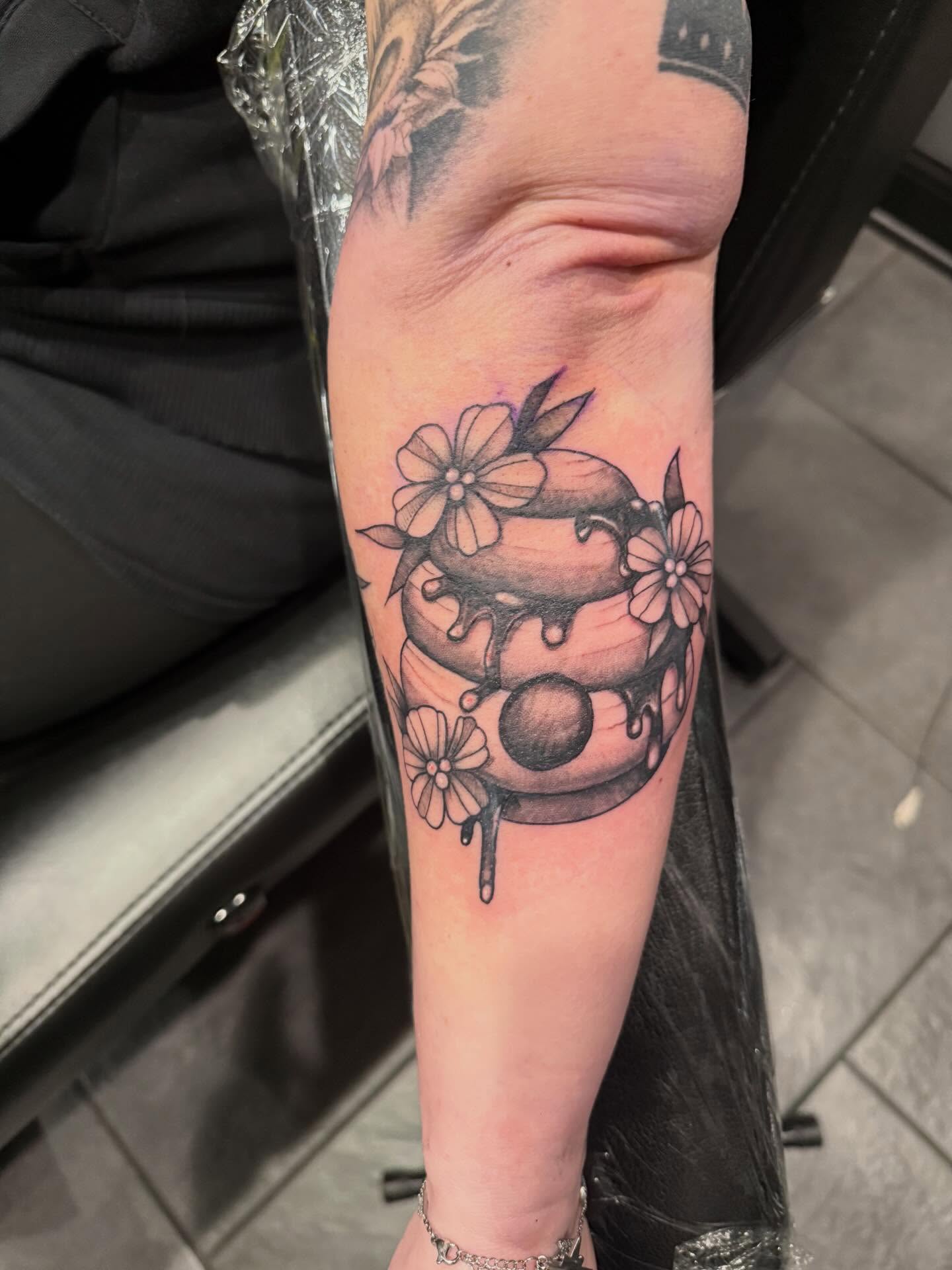 Dripping honeycomb with flowers black and grey tattoo on the forearm by Courtney