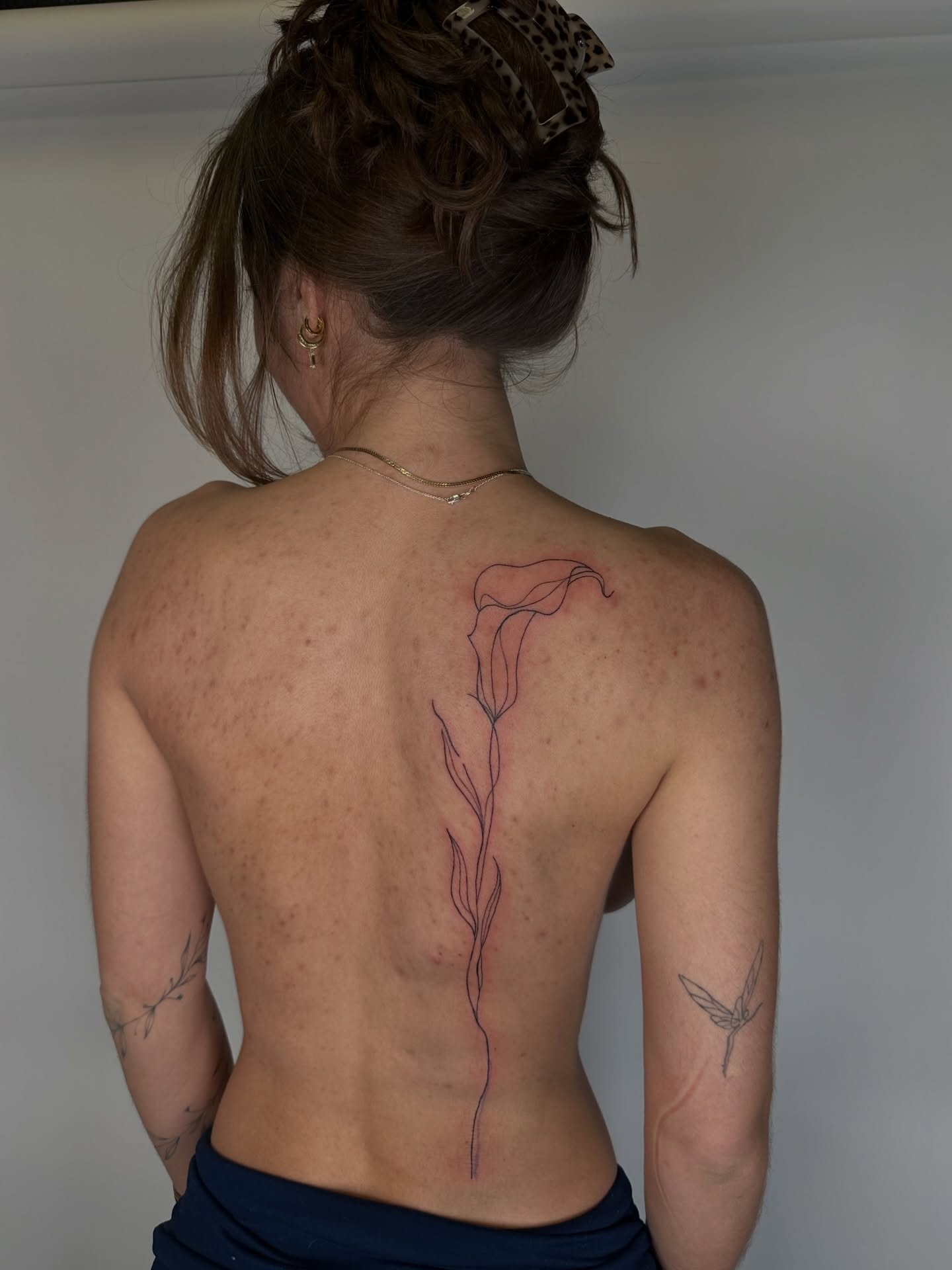 Calla lily fine line tattoo on the back by πππππππ π‘ π±πππππ πΌπ°