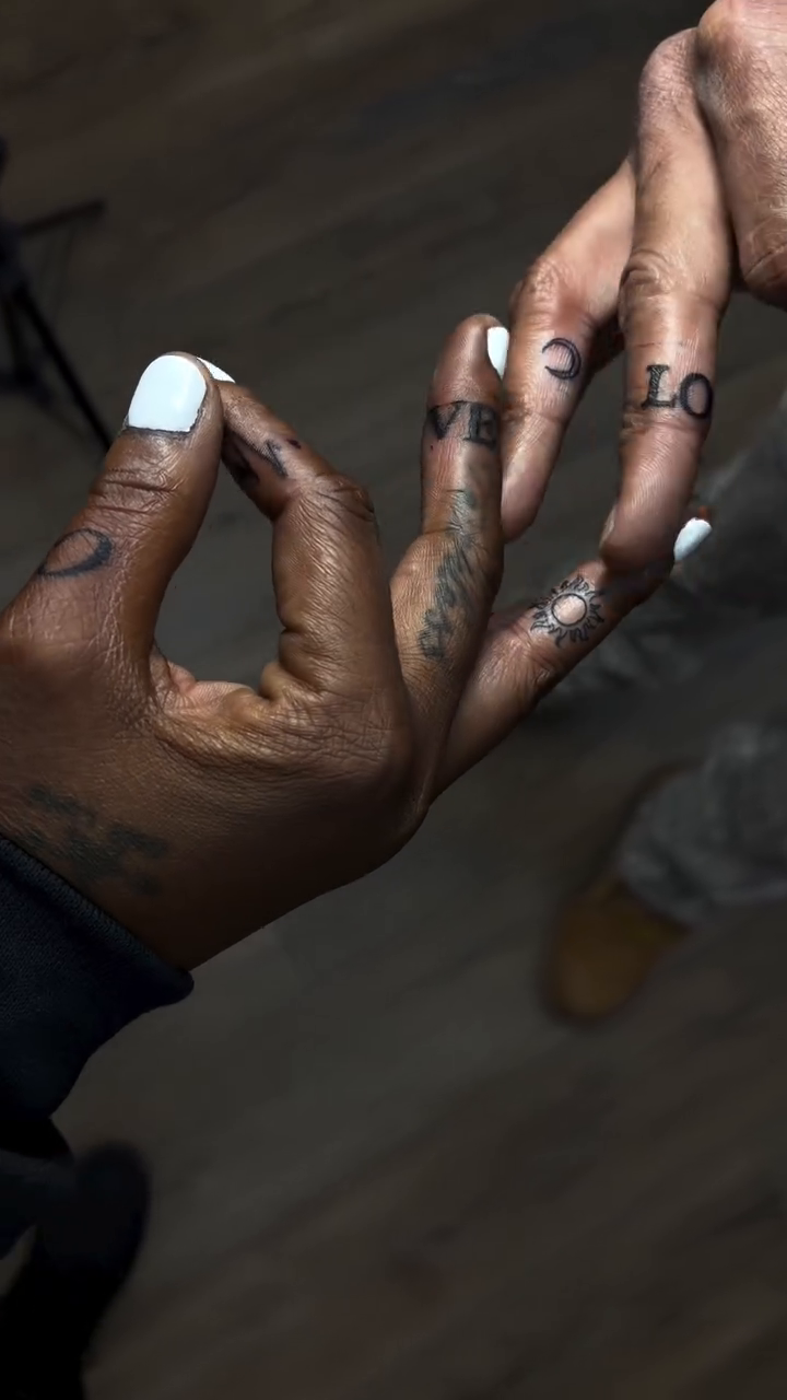Finger tattoos spelling 'LOVE' lettering tattoo on the hand by Mike Tatts