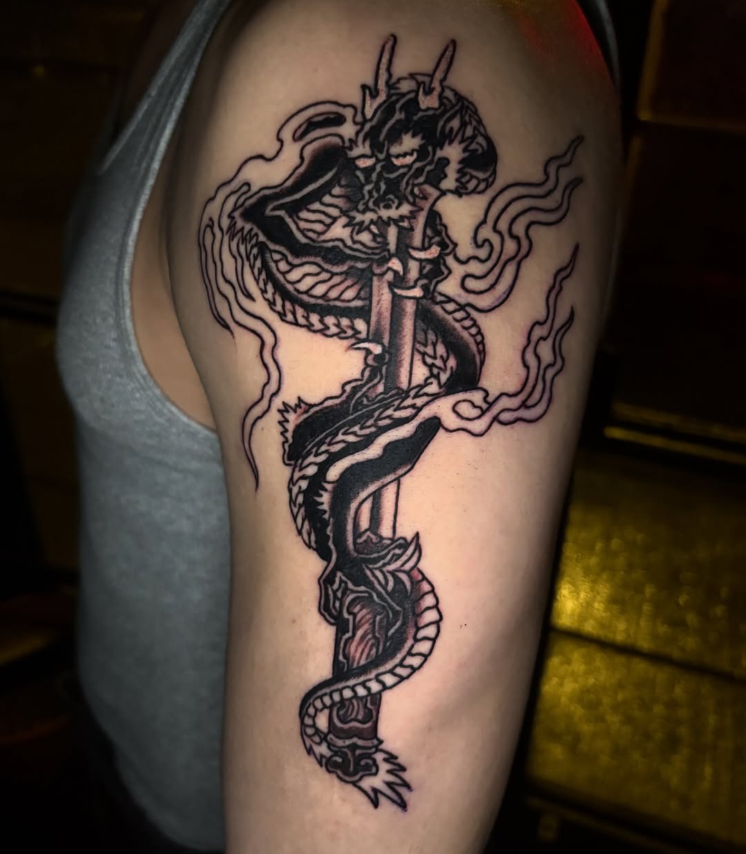 Dragon on a sword Japanese tattoo on the upper arm by Gabi Elia