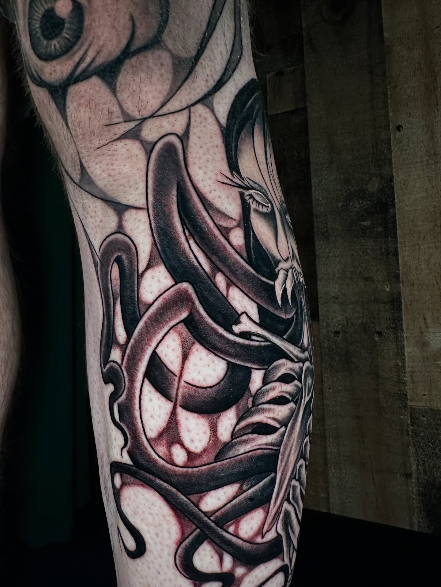 Snake and mask realism tattoo on the forearm by Sam Minneci
