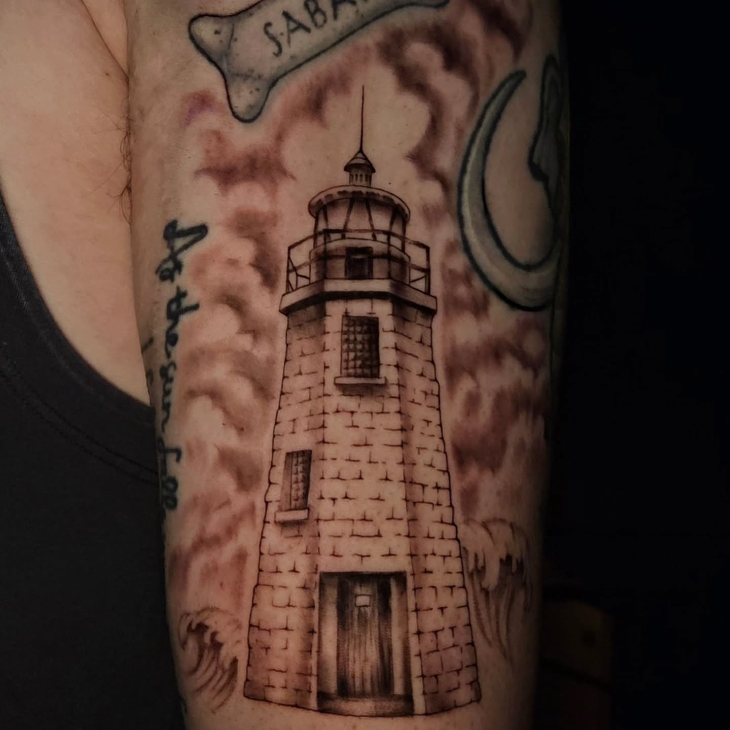 Lighthouse black and grey tattoo on the forearm by Courtlyn Bliss