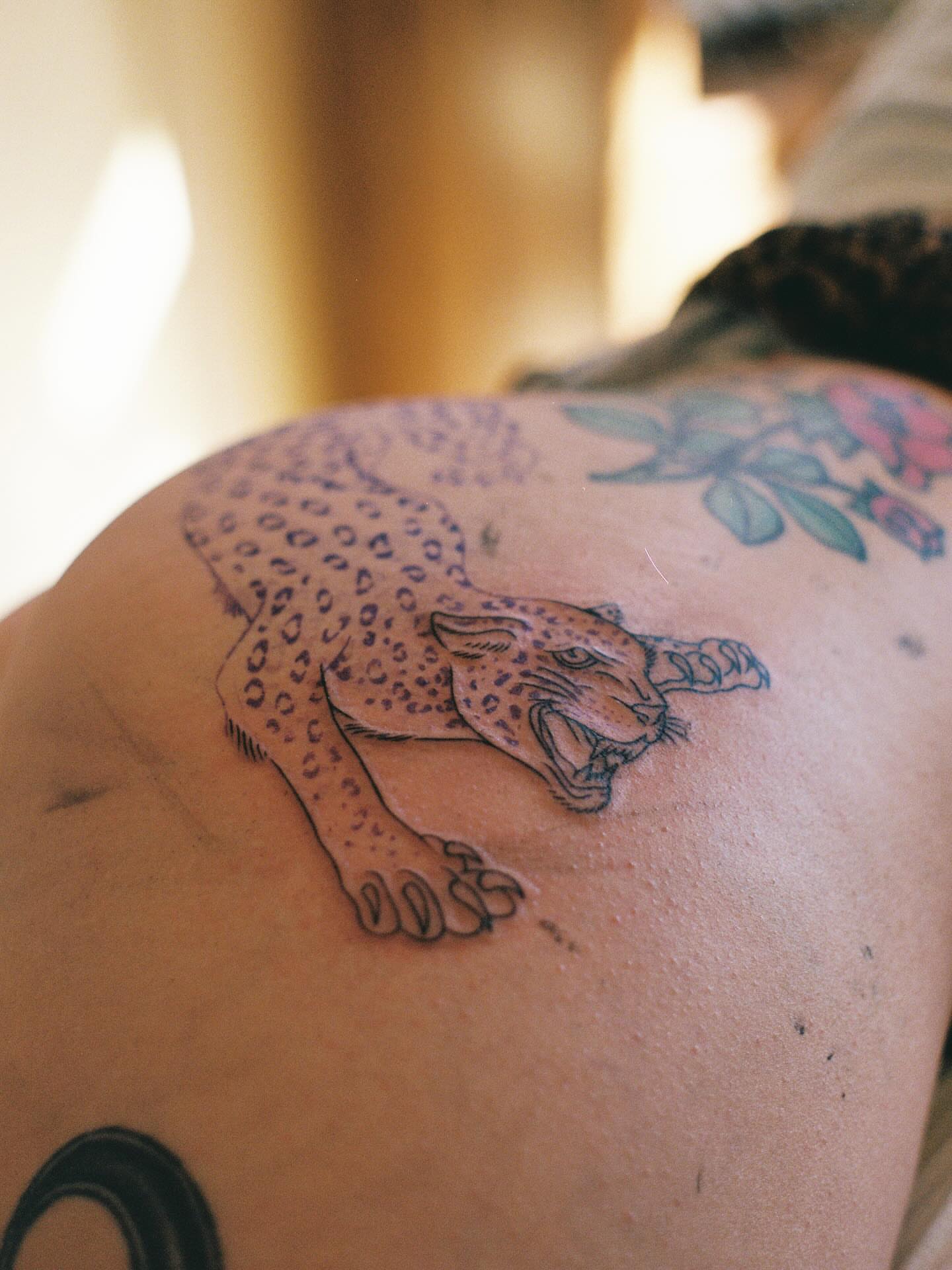 Leopard black and grey tattoo on the shoulder by Maddie Hammell