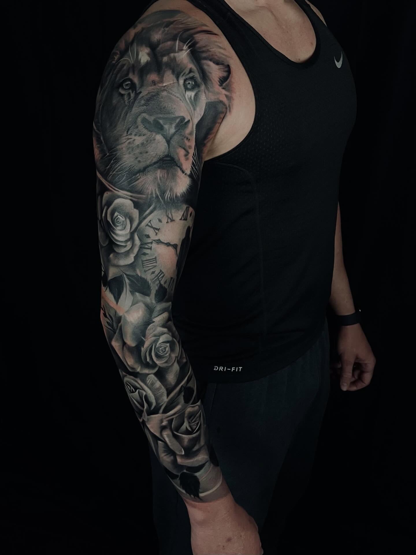Lion and roses realism tattoo on the upper arm by Levi Tattoo Artist, Utah