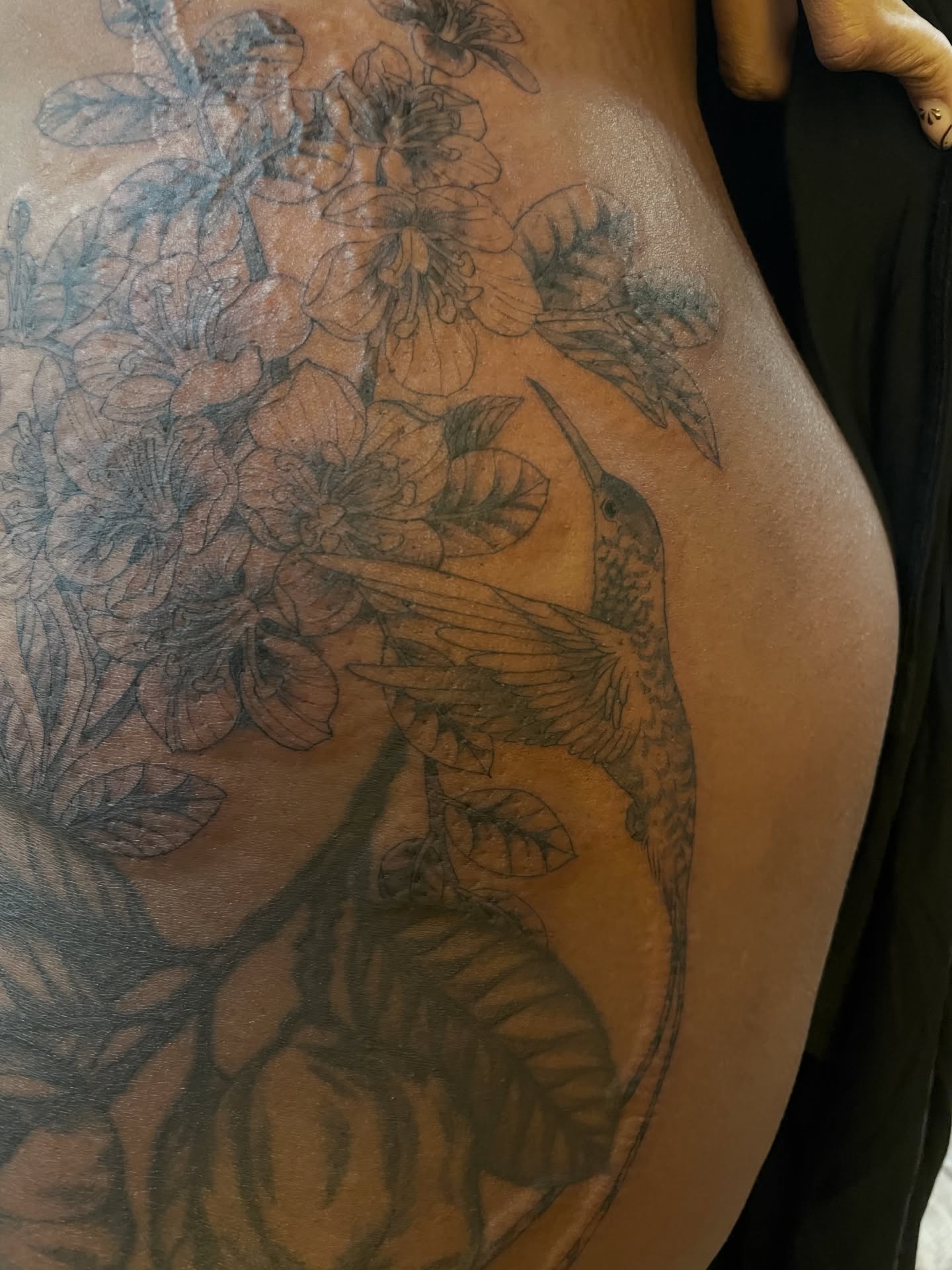 Hummingbird and flowers black and grey tattoo on the thigh by Eryn, Portland, Oregon