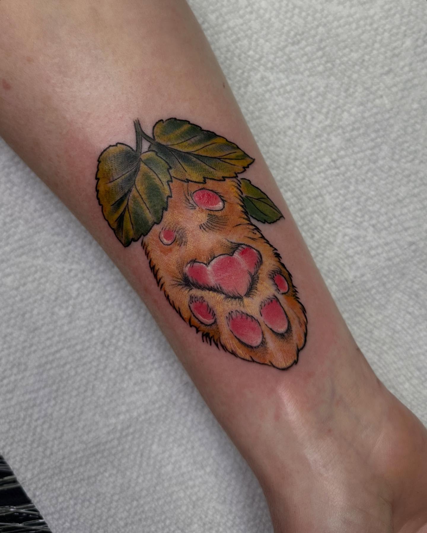 Raspberry paw print American traditional tattoo on the forearm by Heather Tattoos Danvers MA