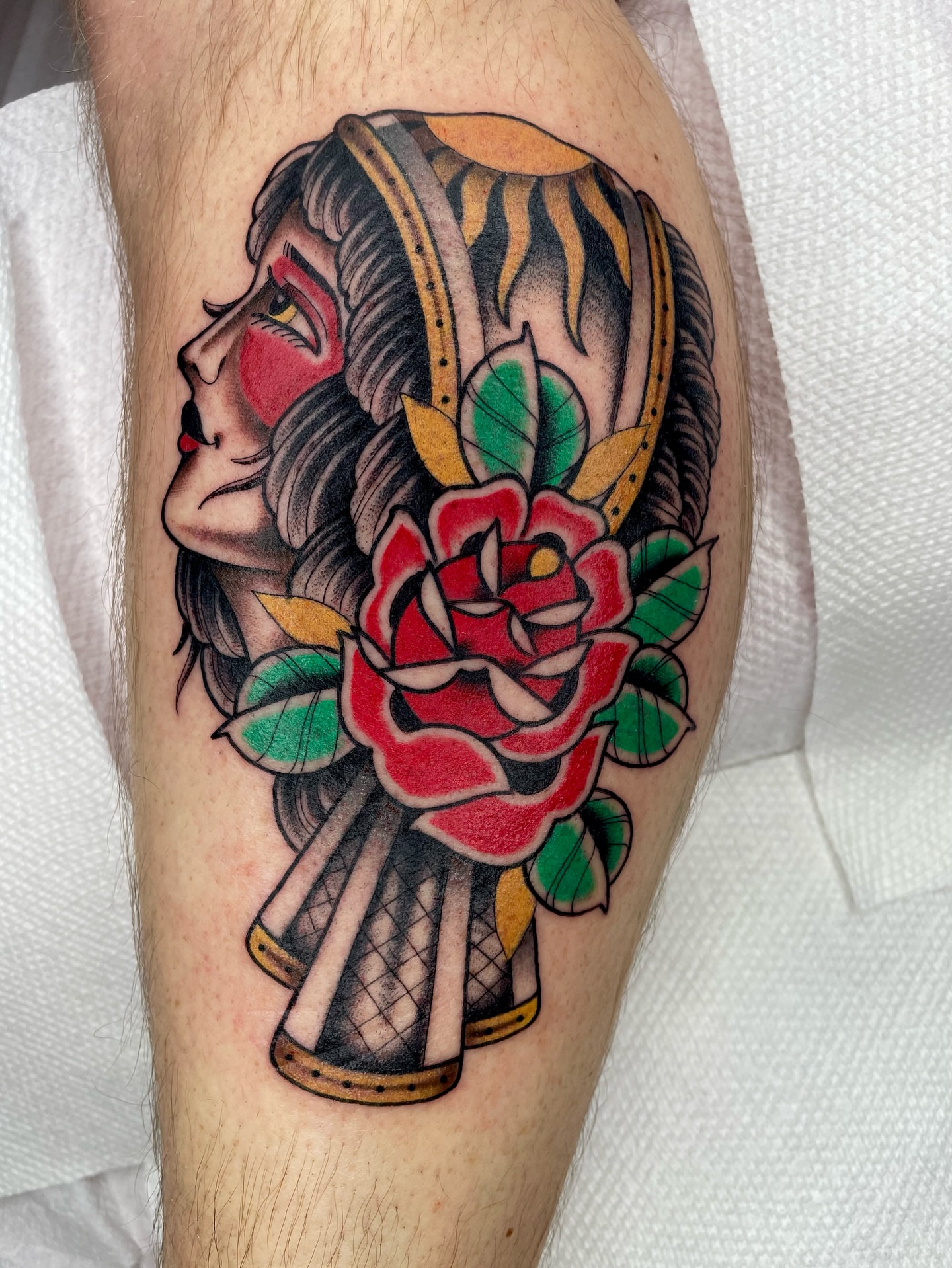 Woman with rose American traditional tattoo on the forearm by Josh Johns