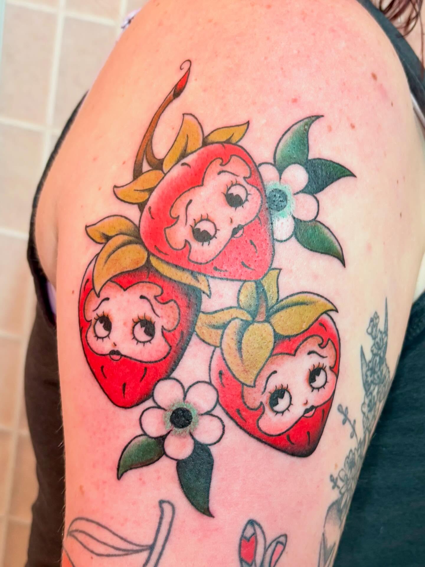 Strawberry characters American traditional tattoo on the shoulder by Leah Leinani