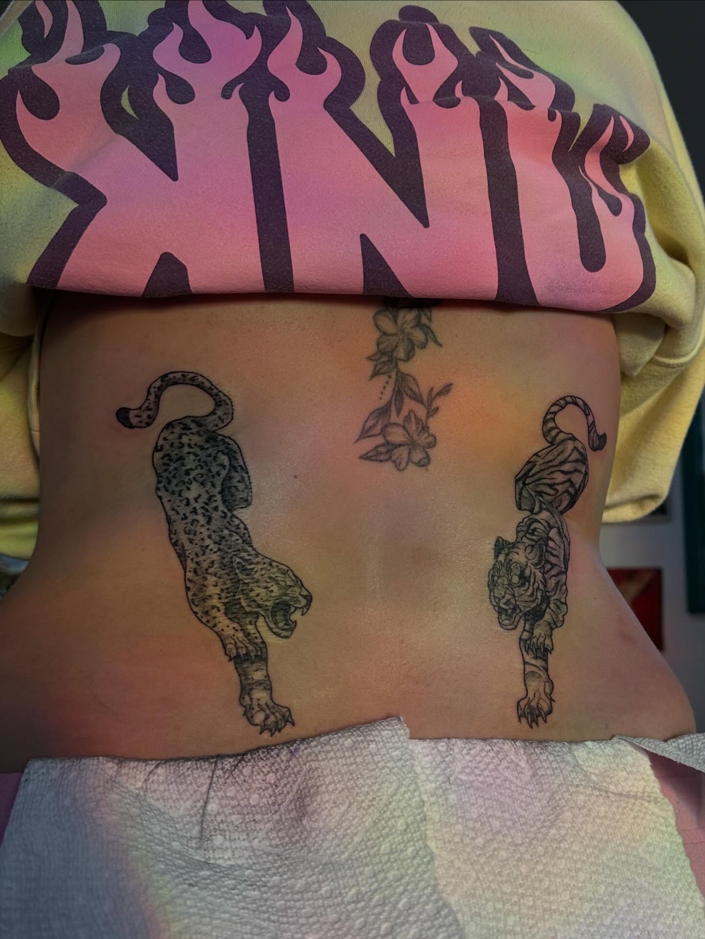 Leopard and tiger black and grey tattoo on the torso by Maddie Neibert