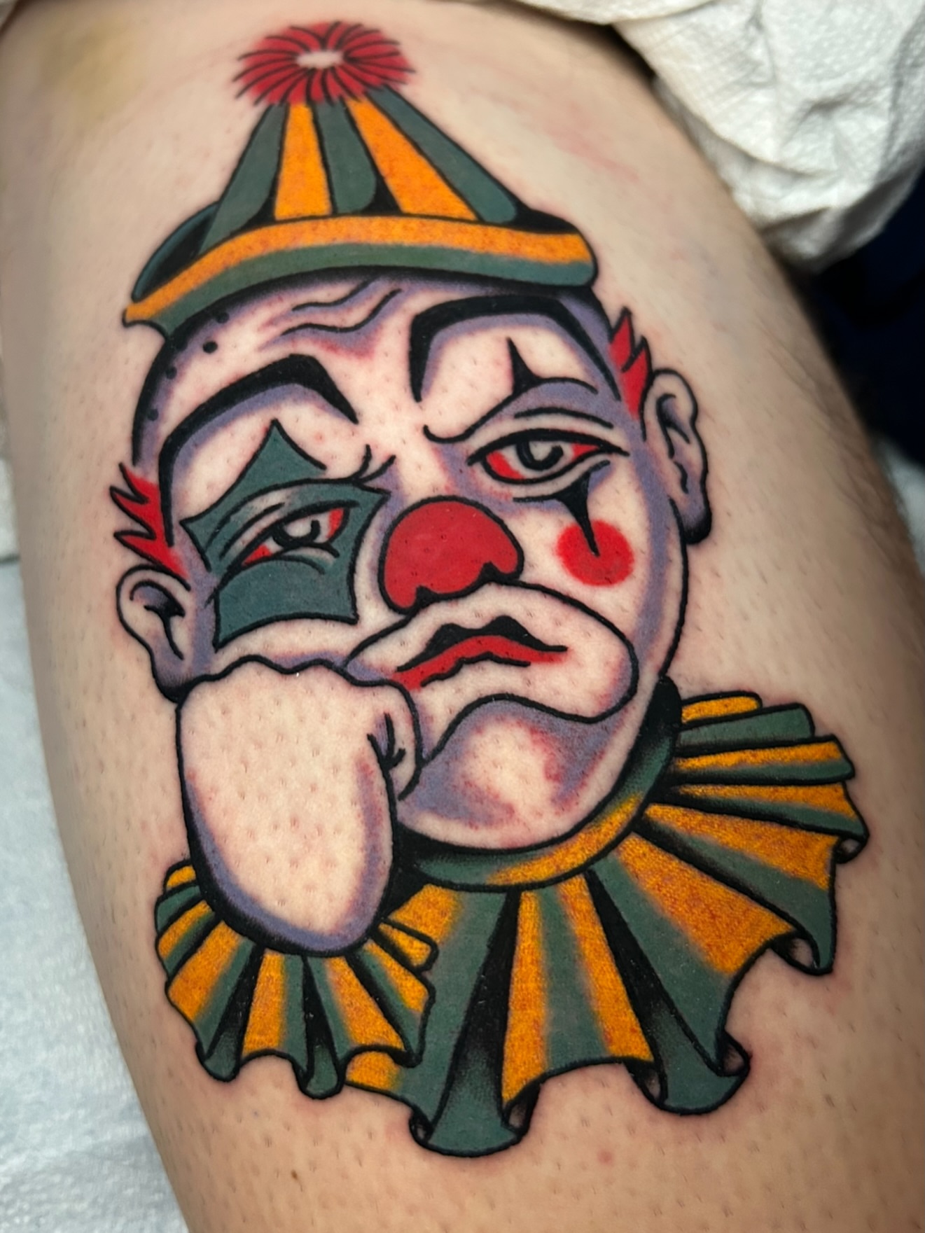 Clown American traditional tattoo on the thigh by Mitch Hoggard