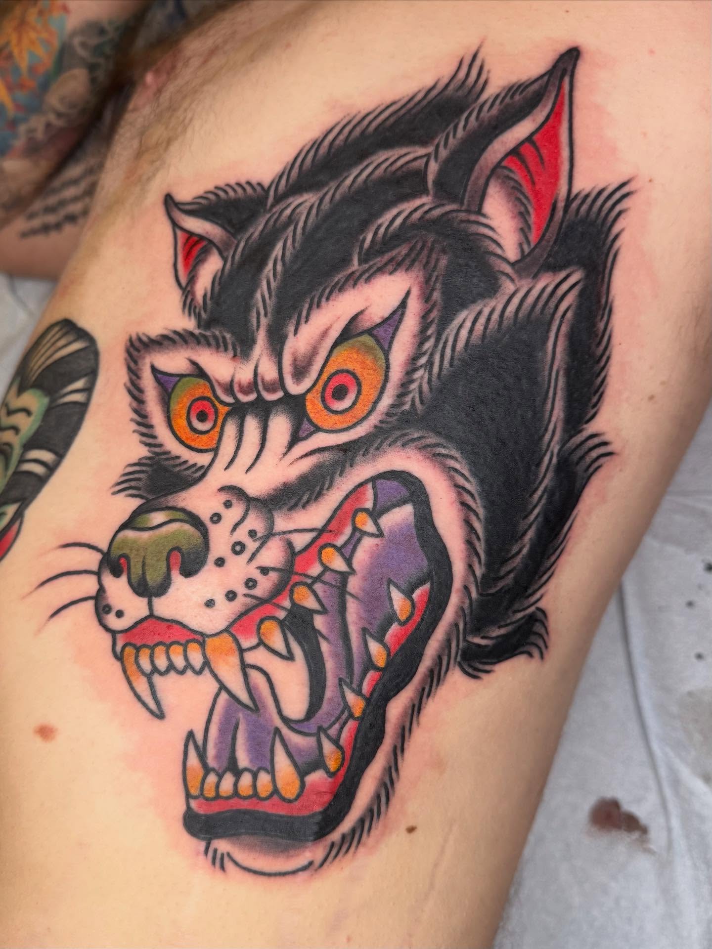 Wolf American traditional tattoo on the thigh by Emma Eaton