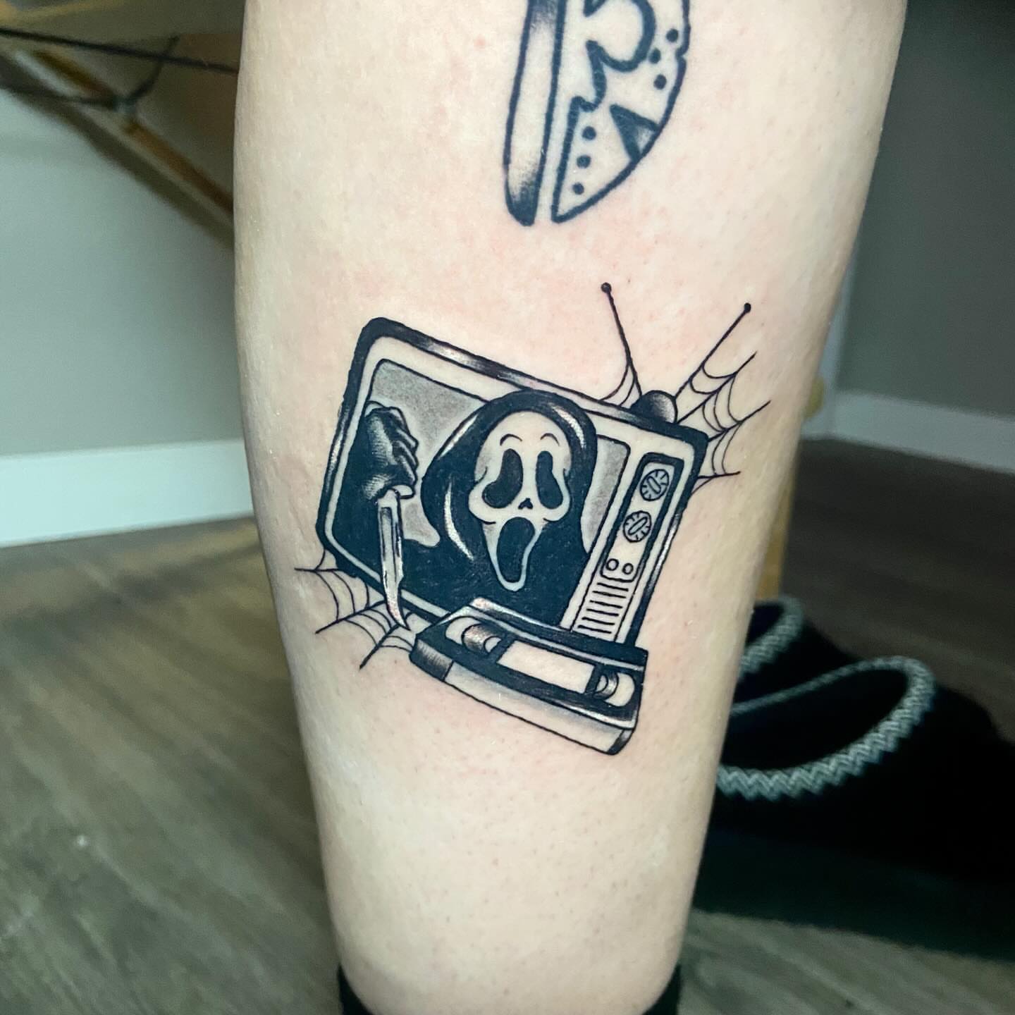 Tv with ghostface mask black and grey tattoo on the forearm by โ๏ธ ๐๐ฎ๐ฐ๐ธ๐ถ๐ฒ โ๏ธ