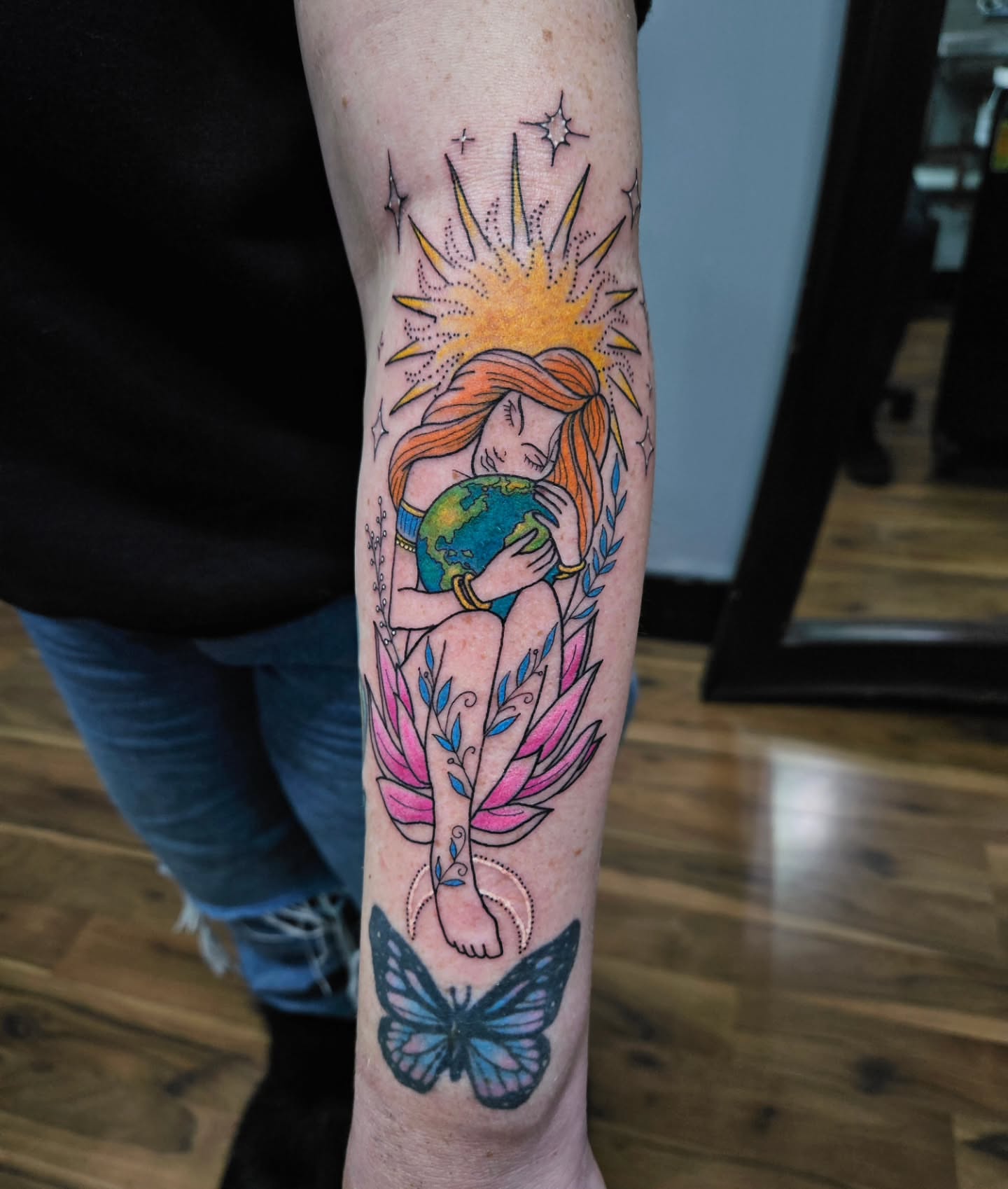 Woman holding globe dotwork tattoo on the forearm by Danny