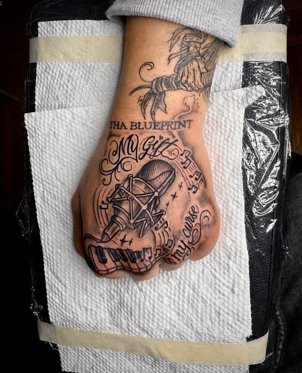 Music-themed tattoo black and grey tattoo on the hand by JayyeSosa