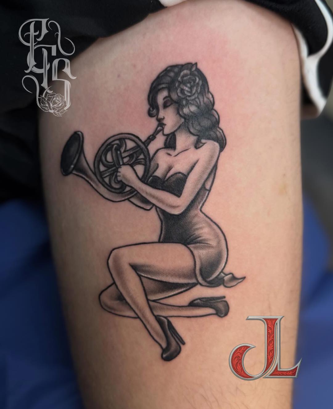 Female figure playing trumpet black and grey tattoo on the thigh by Faithful Tattoo Studio