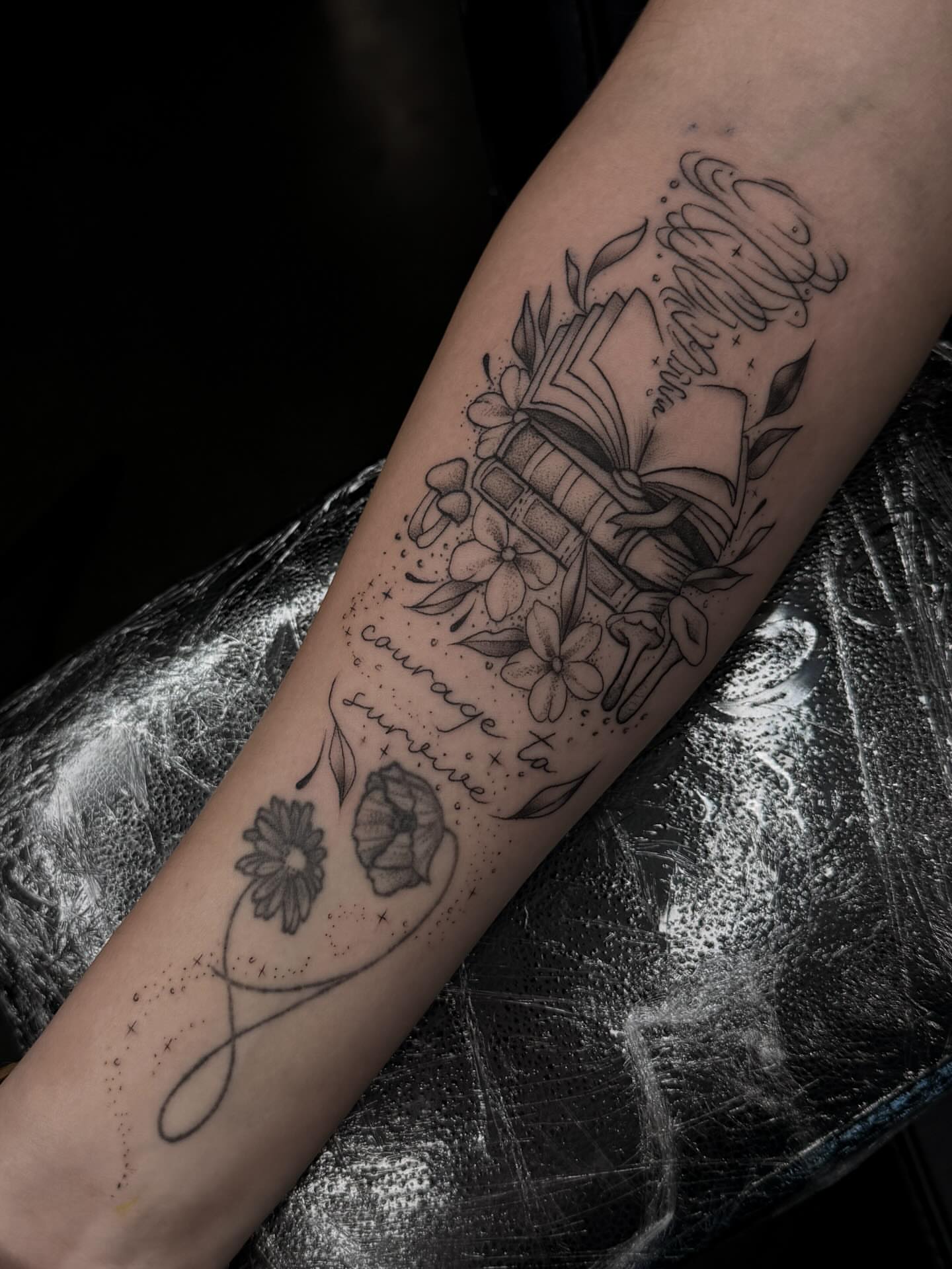 Book and flowers dotwork tattoo on the forearm by Susie Maj