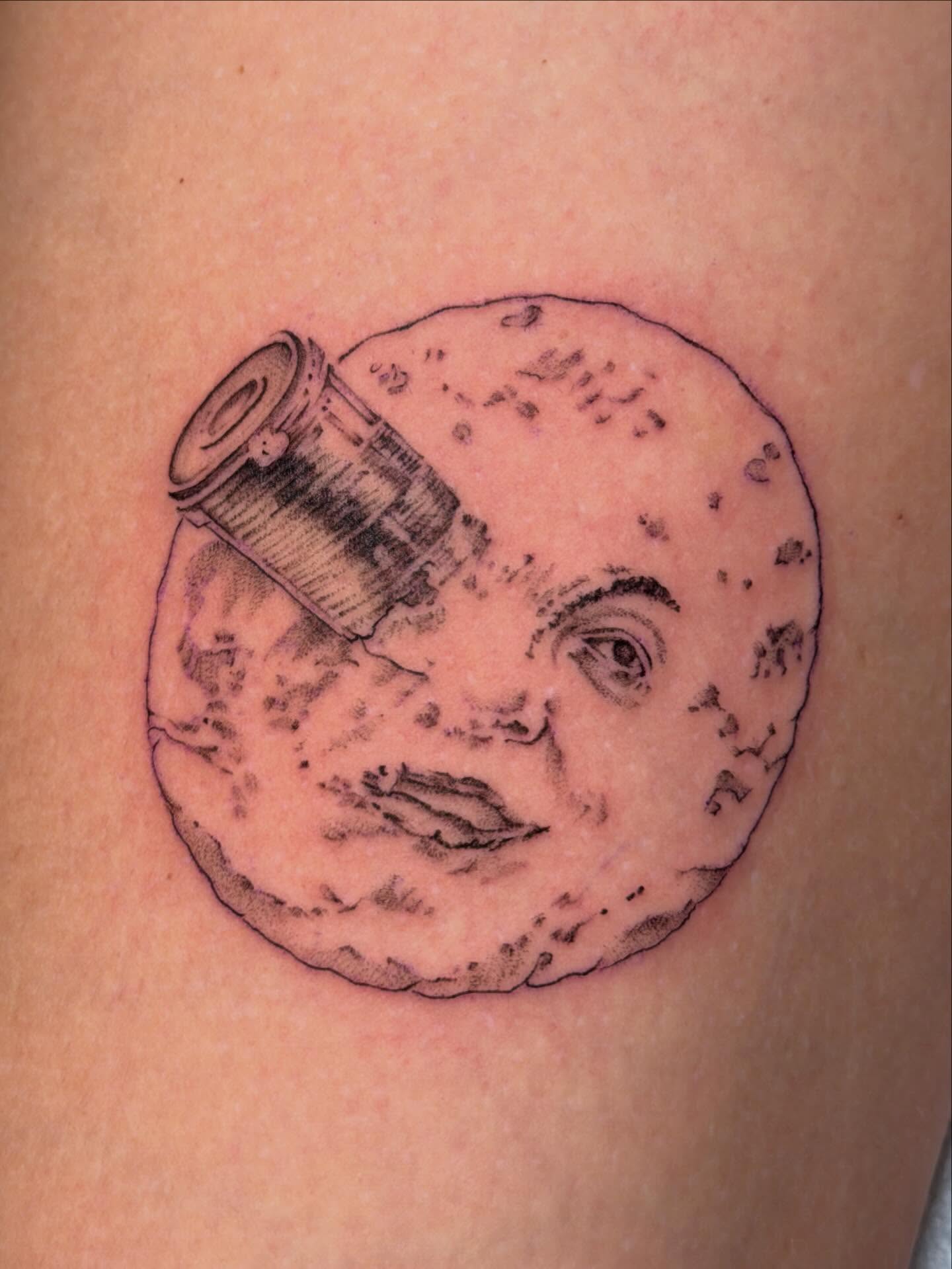 Moon with face and telescope realism tattoo on the thigh by James Nelson