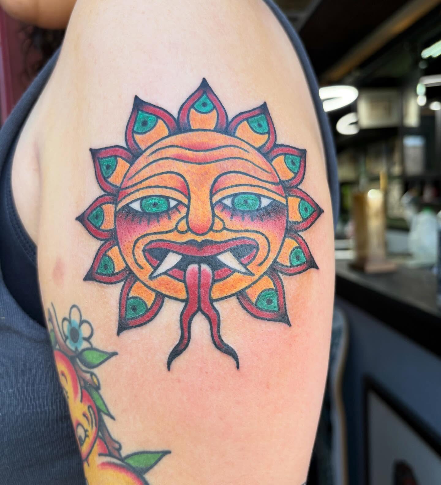 Sun mask American traditional tattoo on the upper arm by ✨Shelby ✨