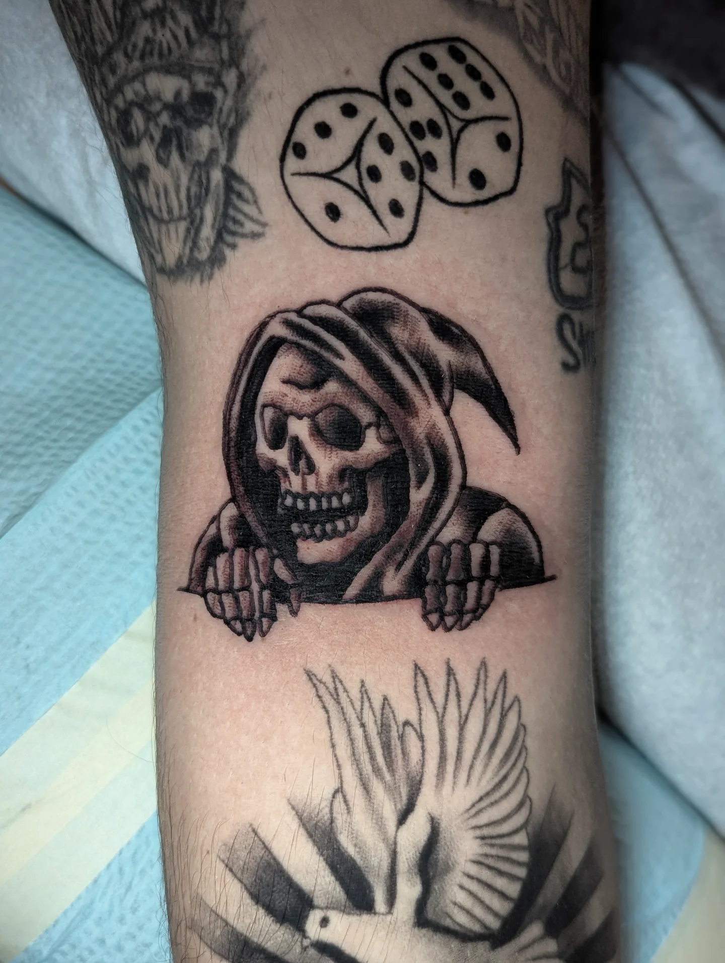 Reaper black and grey tattoo on the forearm by Eric Ward