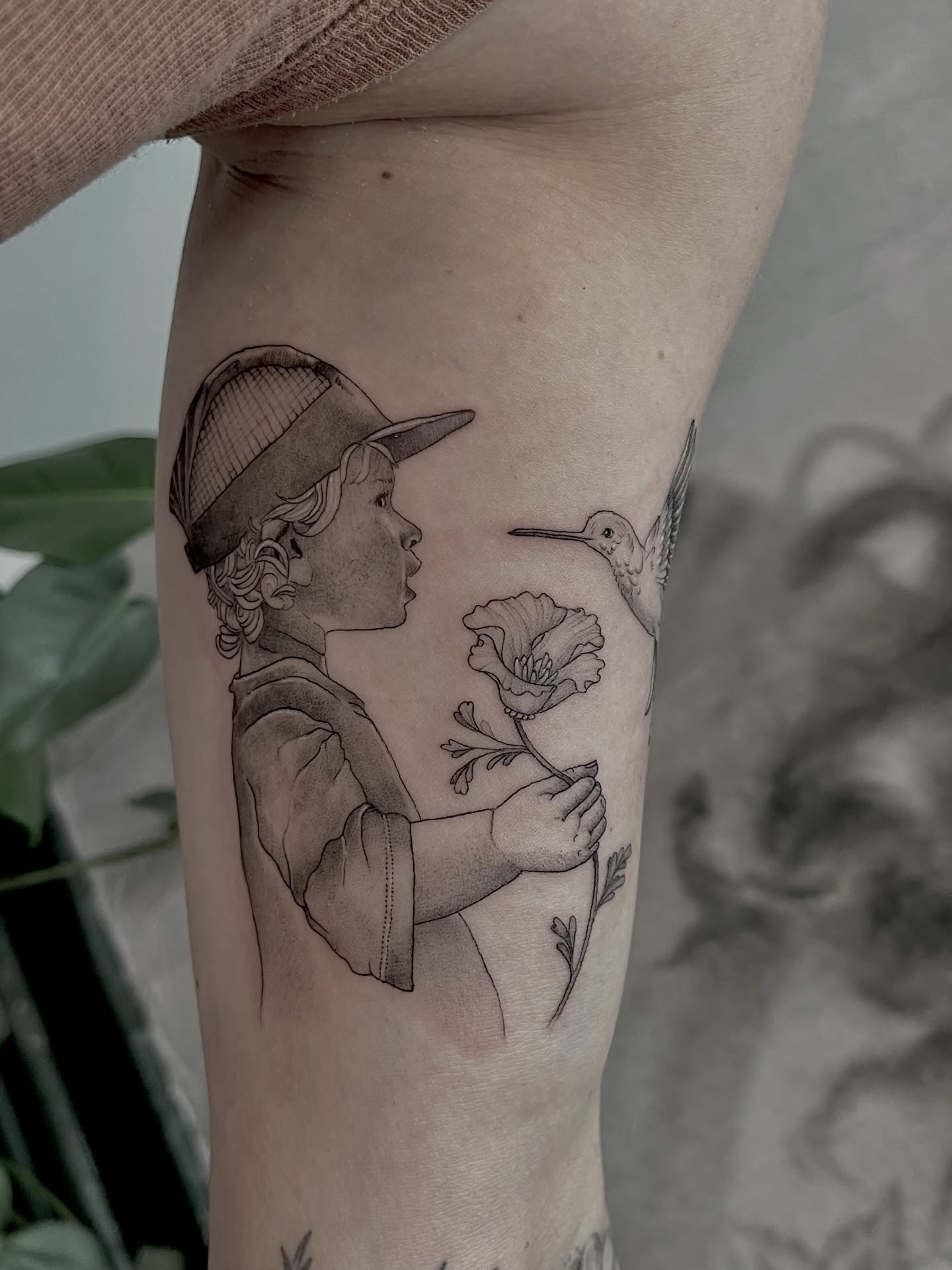 Child with hummingbird and flower dotwork tattoo on the forearm by Lo Gwynn