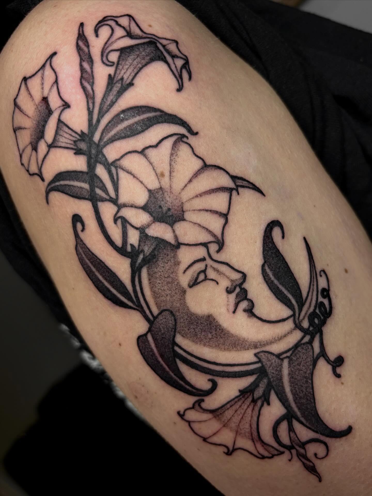 Floral arrangement black and grey tattoo on the thigh by Tara, Exeter, Pennsylvania