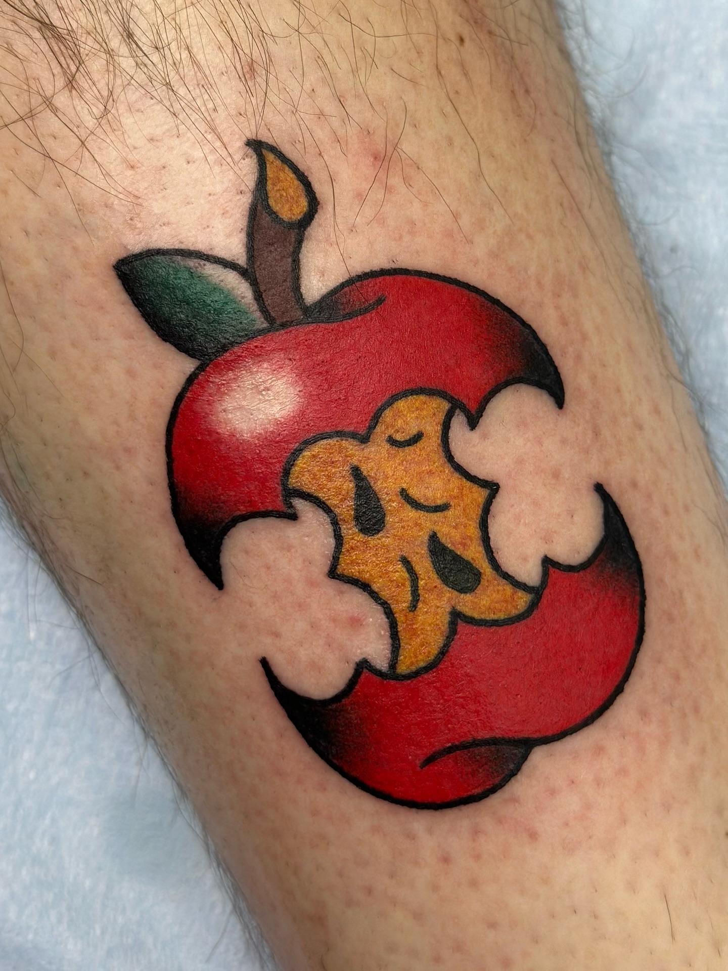 Apple with bite American traditional tattoo on the thigh by Lucy Jay