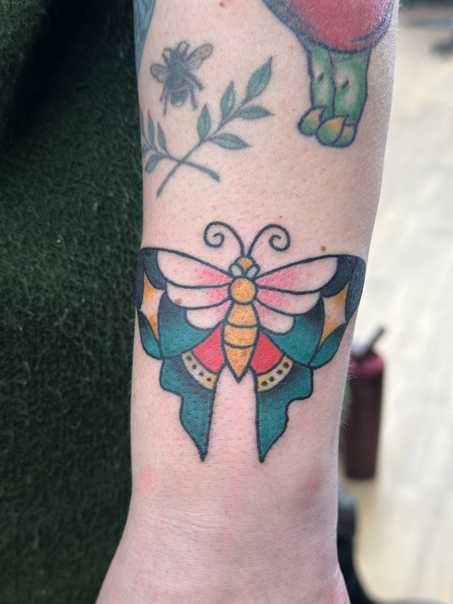Butterfly American traditional tattoo on the forearm by Lucy Jay