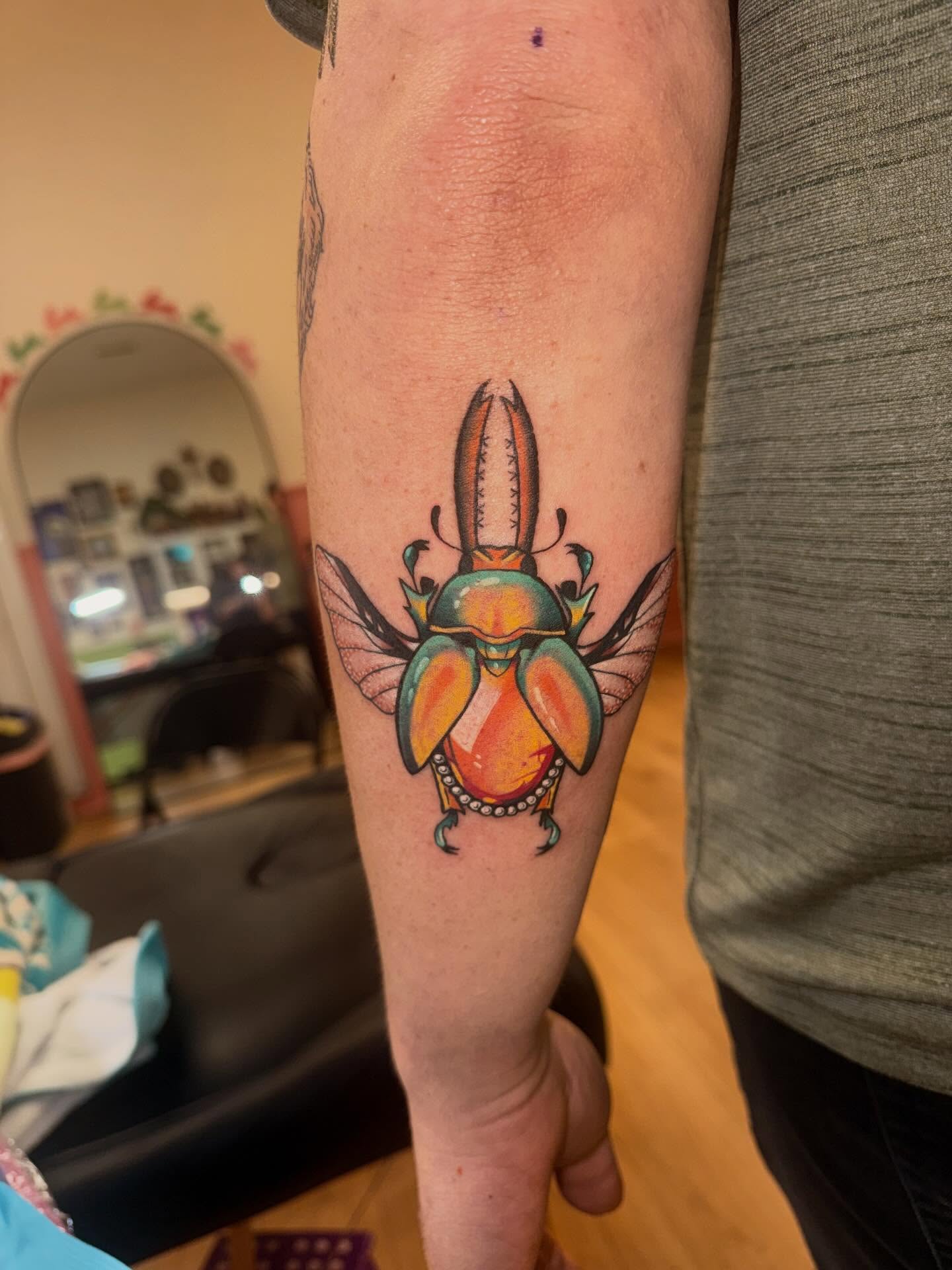 Scarab beetle new school tattoo on the forearm by Laurito