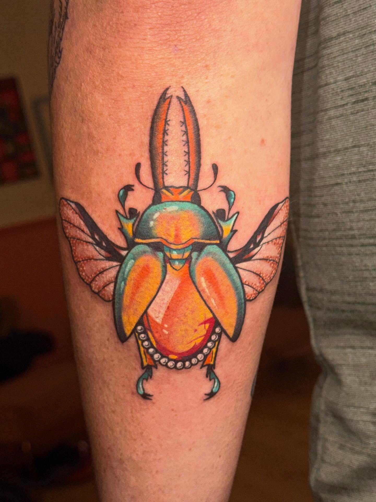 Scarab beetle new school tattoo on the forearm by Laurito