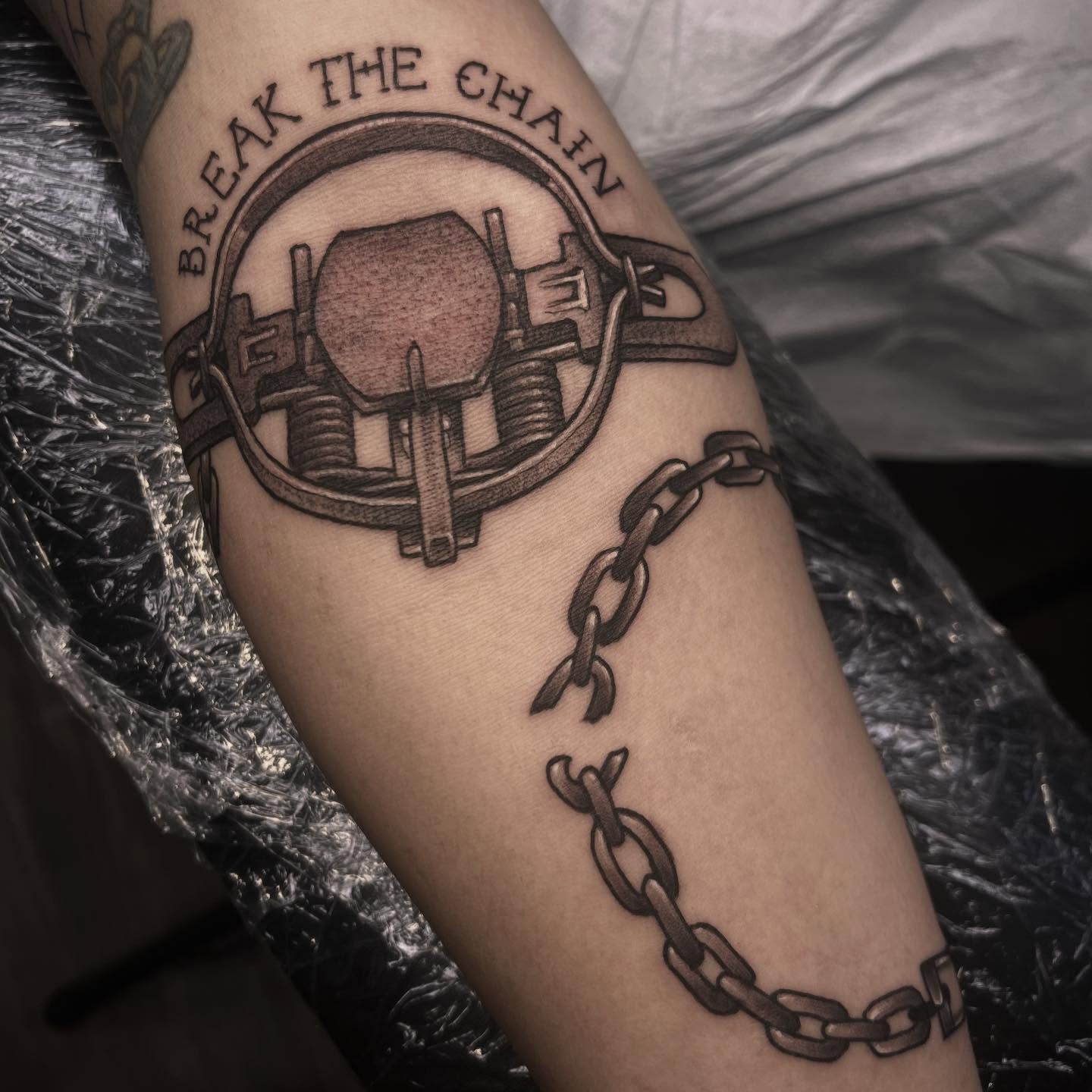 Chain and padlock black and grey tattoo on the forearm by Sarah Foltz