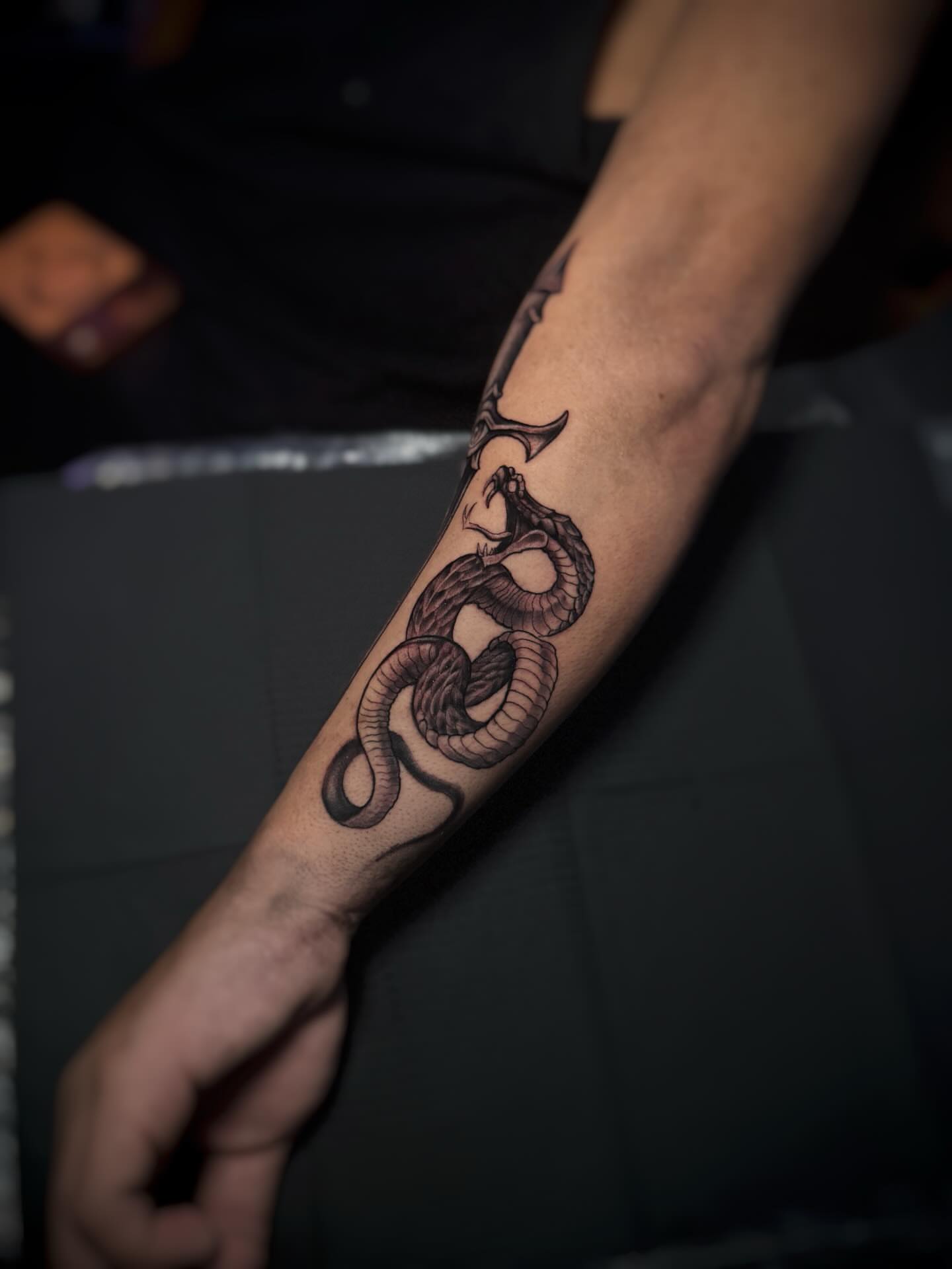 Snake black and grey tattoo on the forearm by Juan Russo