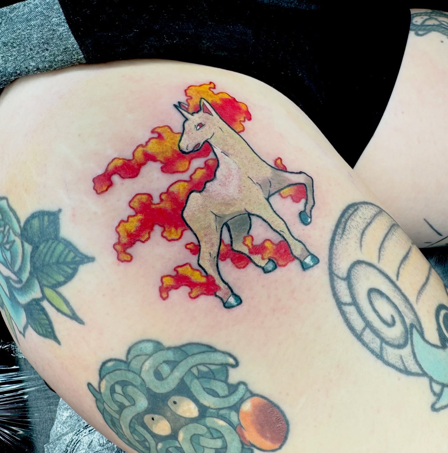 Flaming unicorn new school tattoo on the thigh by Brett Brown