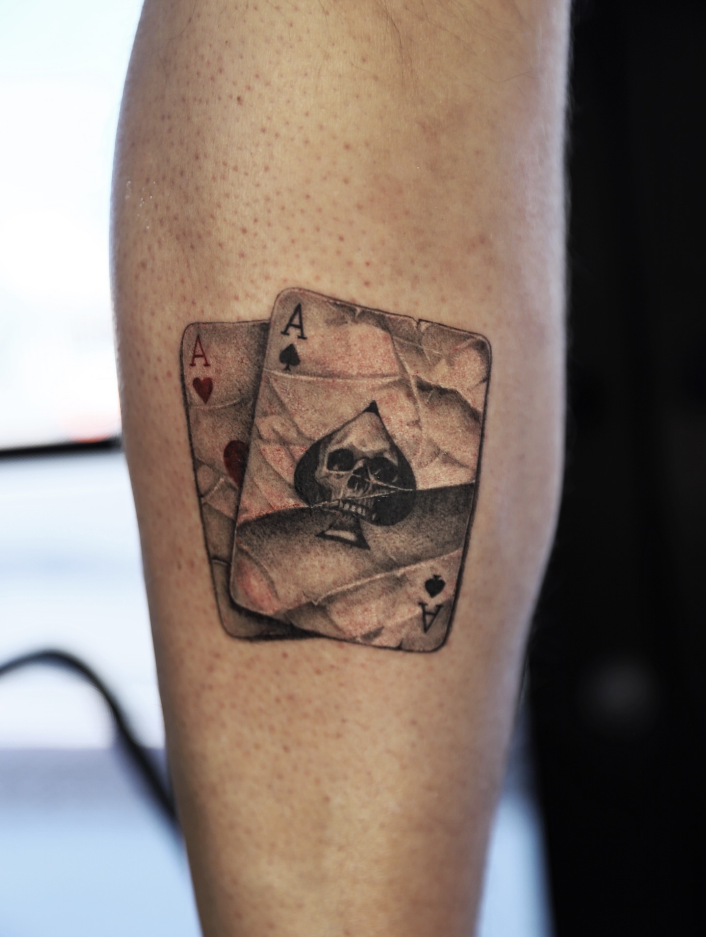 Playing cards with skull realism tattoo on the forearm by Las Vegas tattoo