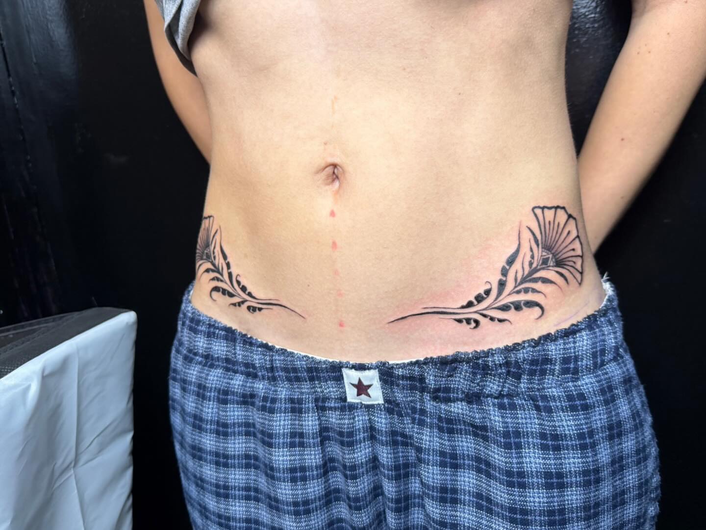 Feather black and grey tattoo on the torso by savannah