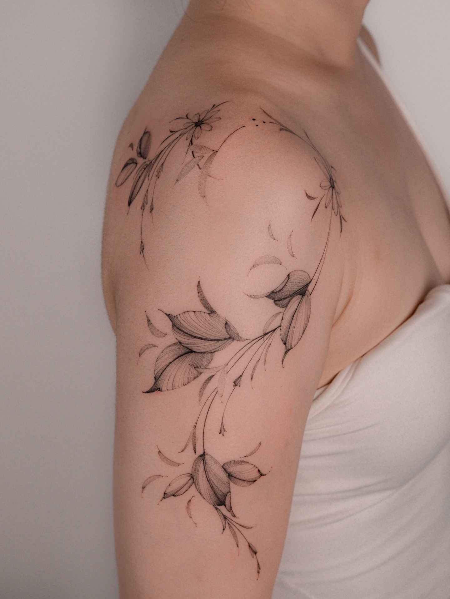 Floral arrangement black and grey tattoo on the shoulder by i flower you