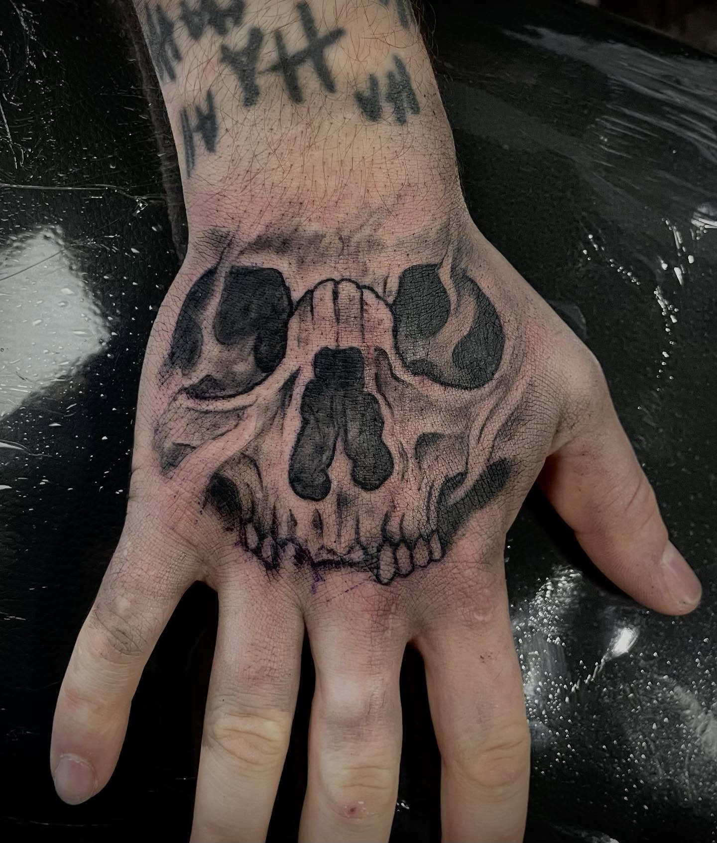 Skull black and grey tattoo on the hand by Logan Casimir