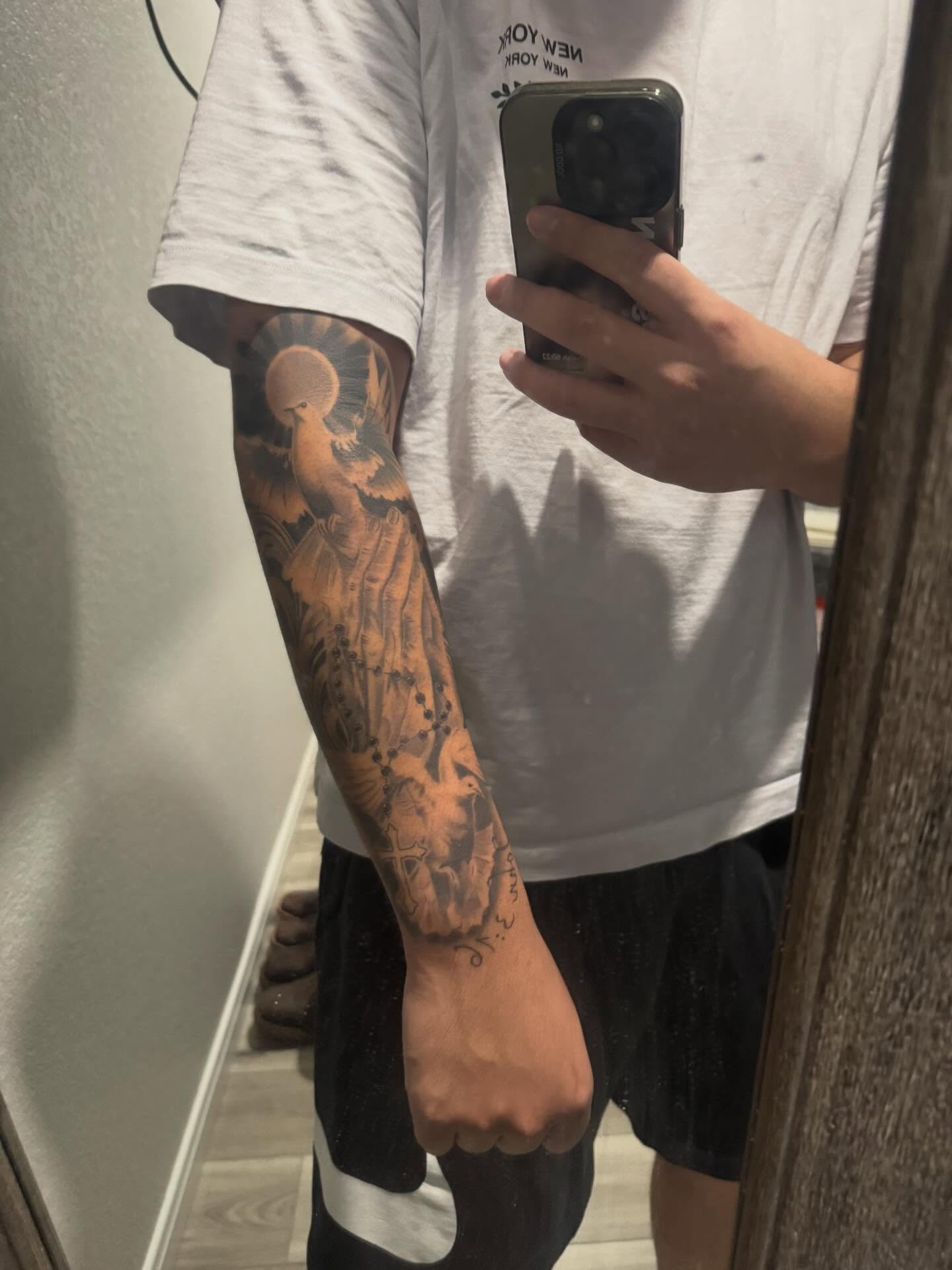 Bird and floral American traditional tattoo on the forearm by Devin