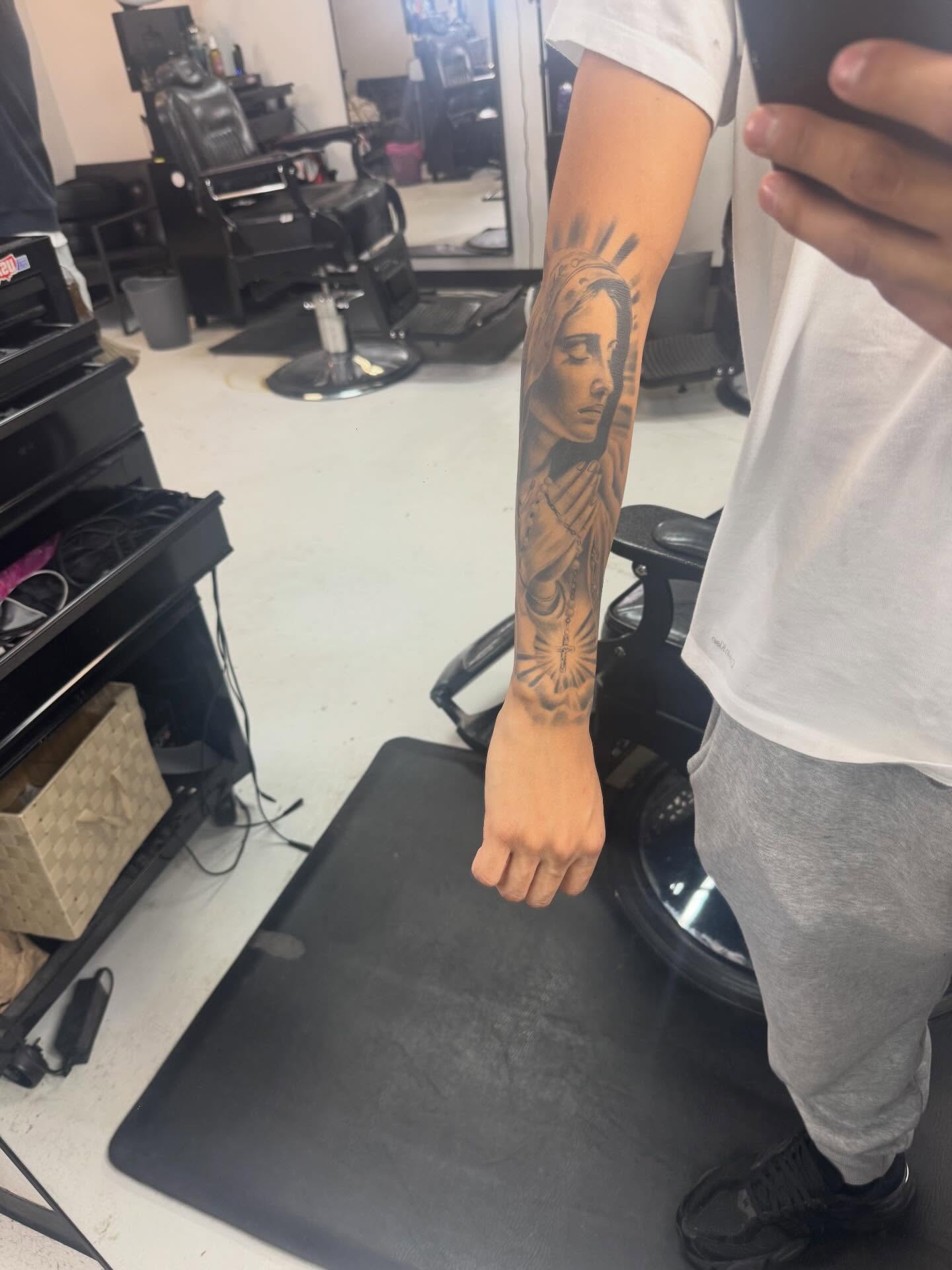 Religious figure black and grey tattoo on the forearm by Devin