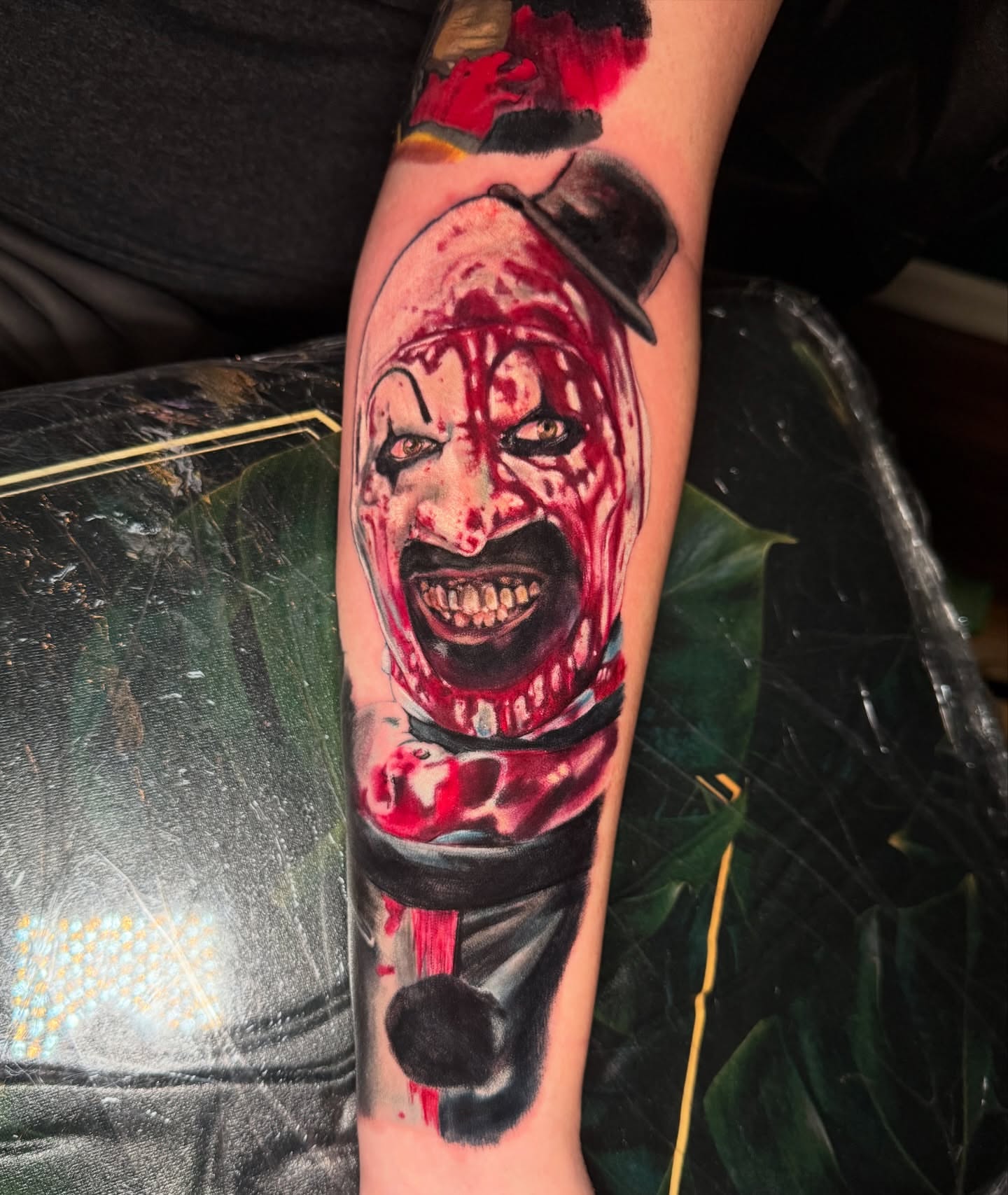 Clown realism tattoo on the forearm by Kelsey Kemp