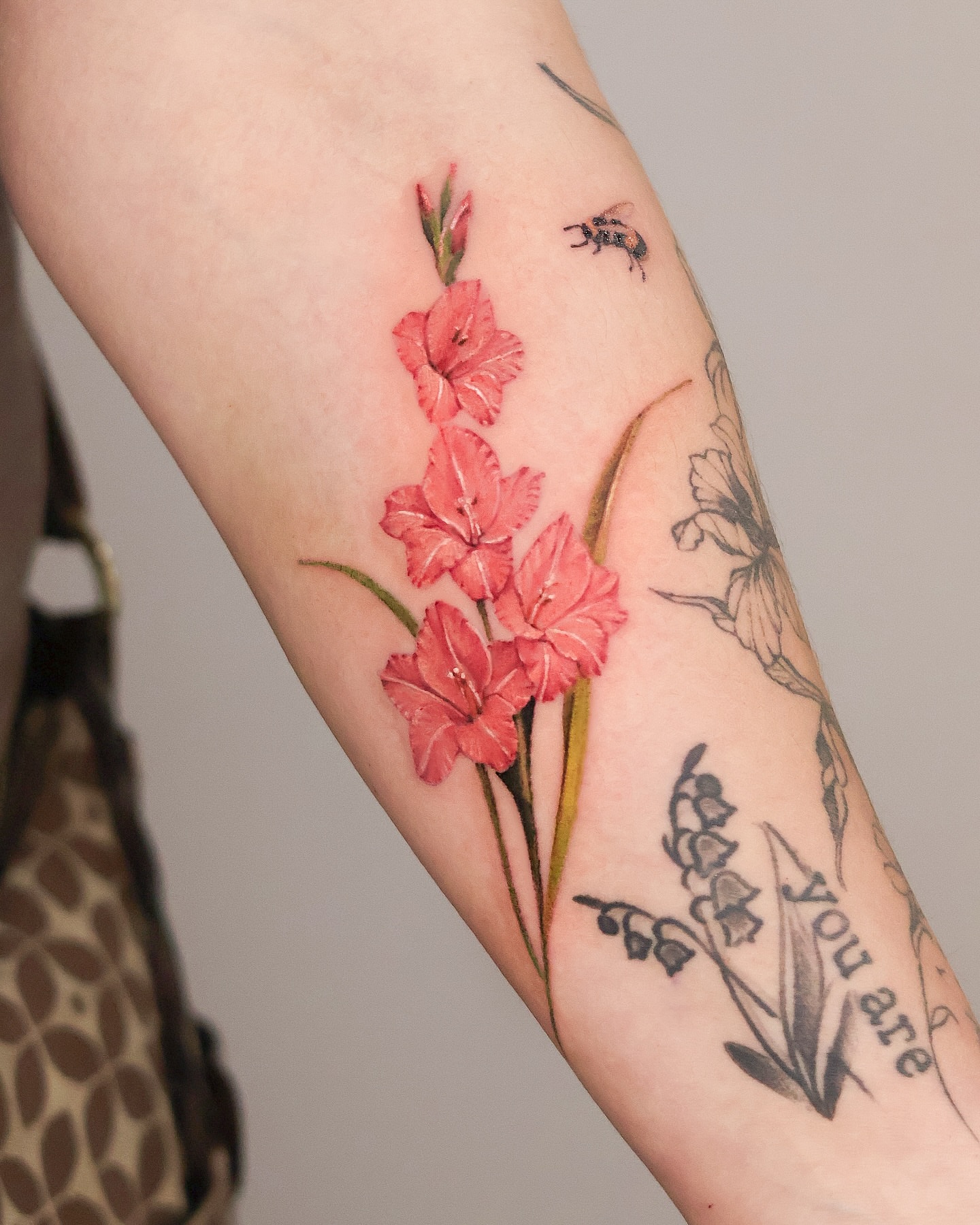 Gladiolus flowers realism tattoo on the forearm by 𝒀𝒖𝒏𝒎𝒊 𝑷𝒂𝒓𝒌