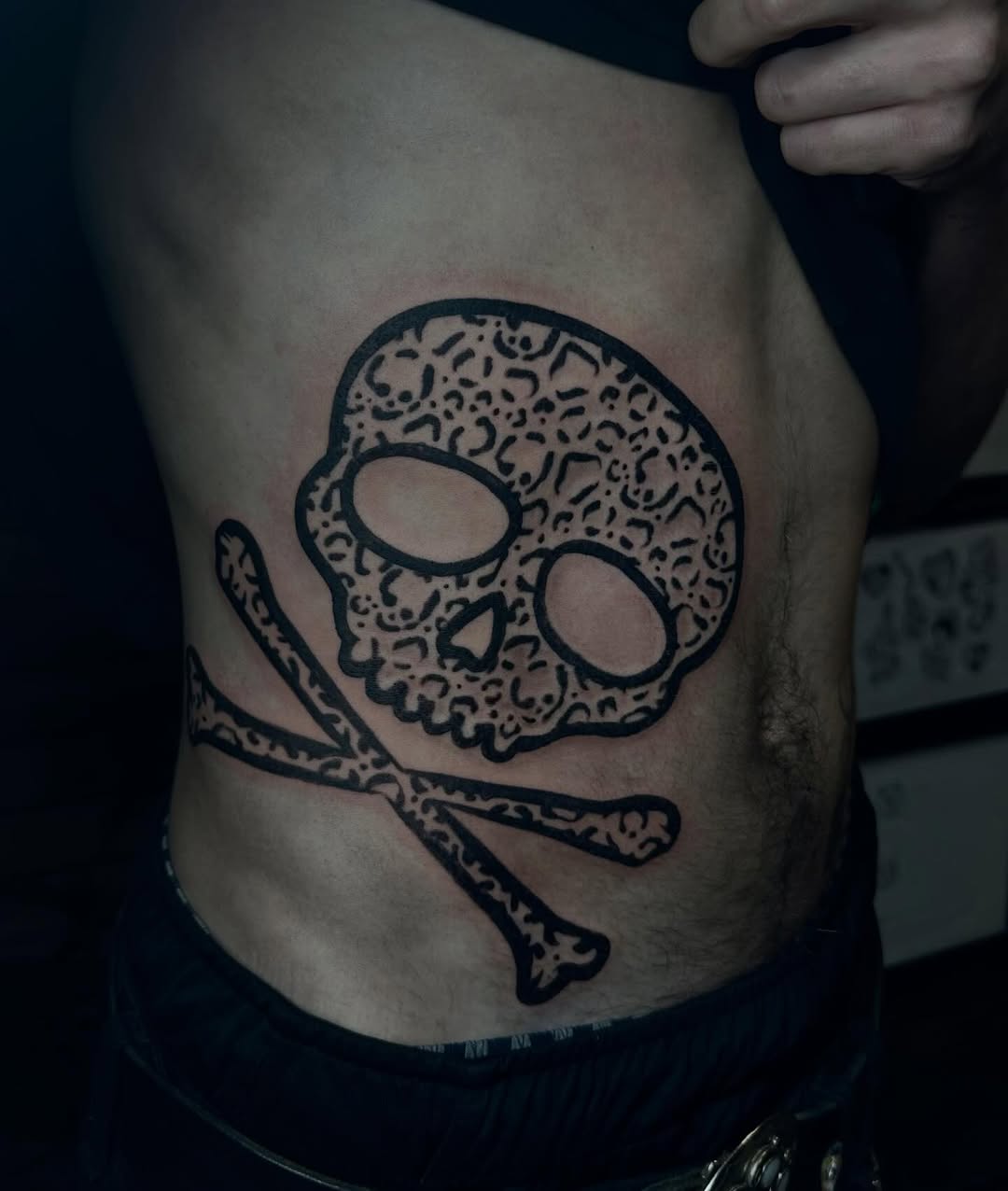 Skull and crossbones realism tattoo on the ribs by emma christine