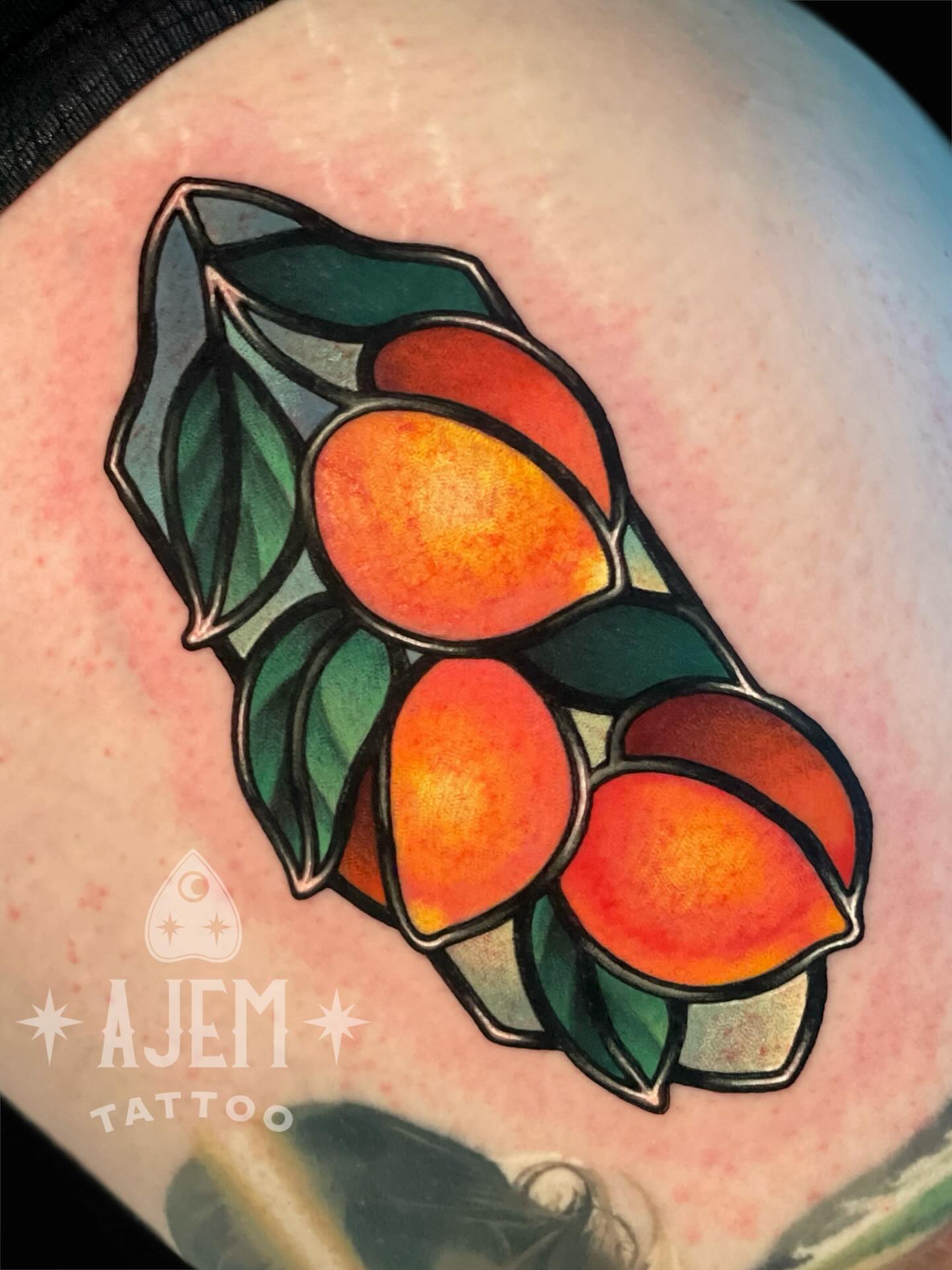 Peach cluster American traditional tattoo on the upper arm by Ash MacIsaac