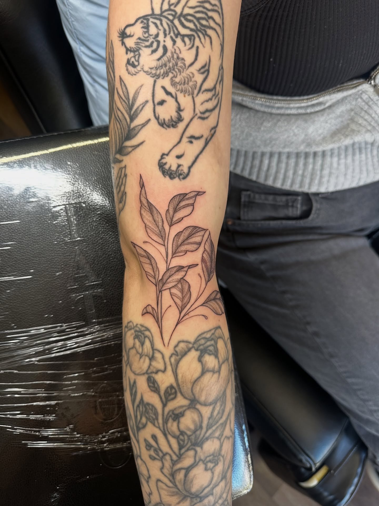 Tiger and flowers black and grey tattoo on the forearm by Priscilla Michels
