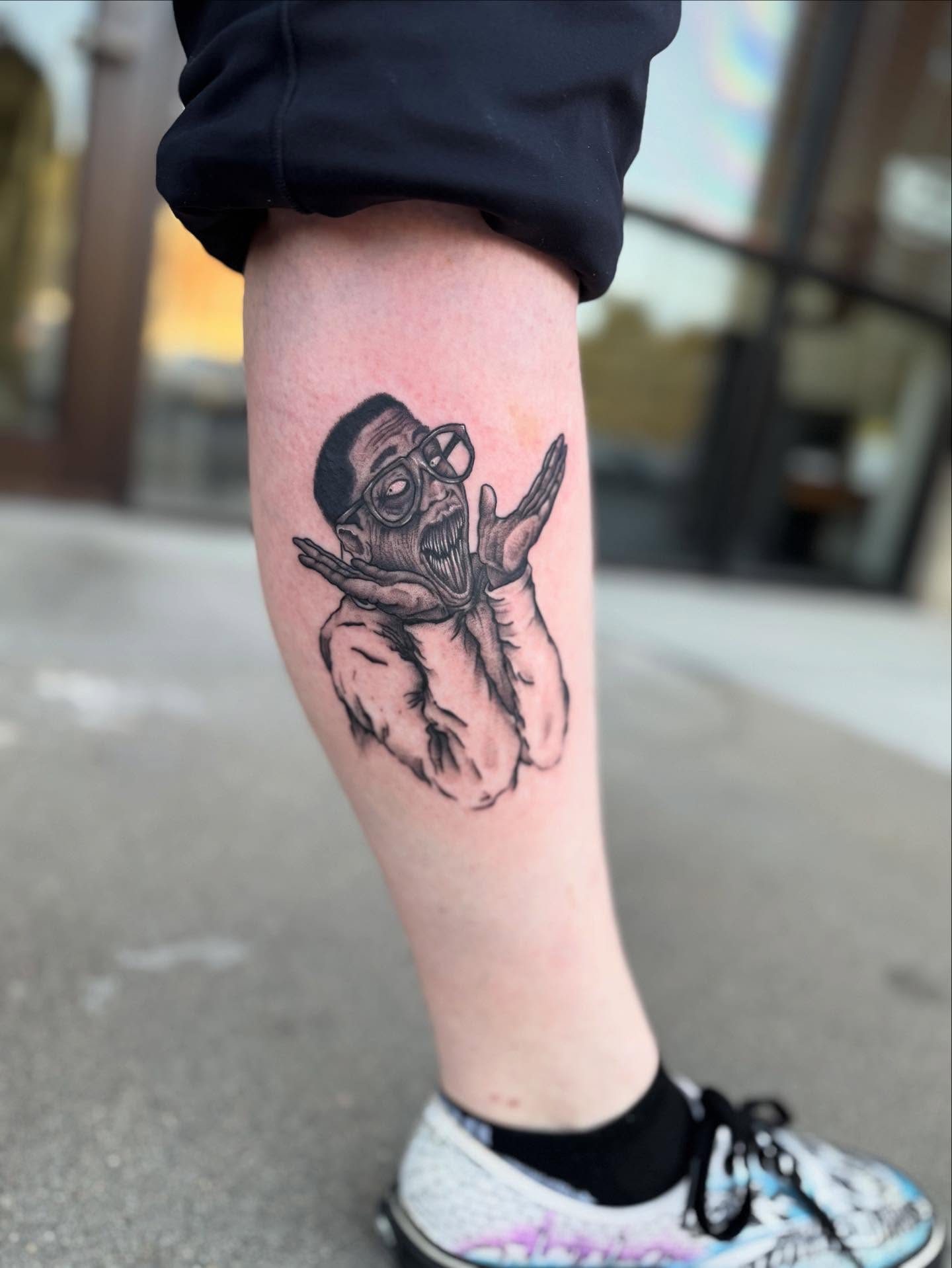 Man with open mouth black and grey tattoo on the forearm by Jon Fleming